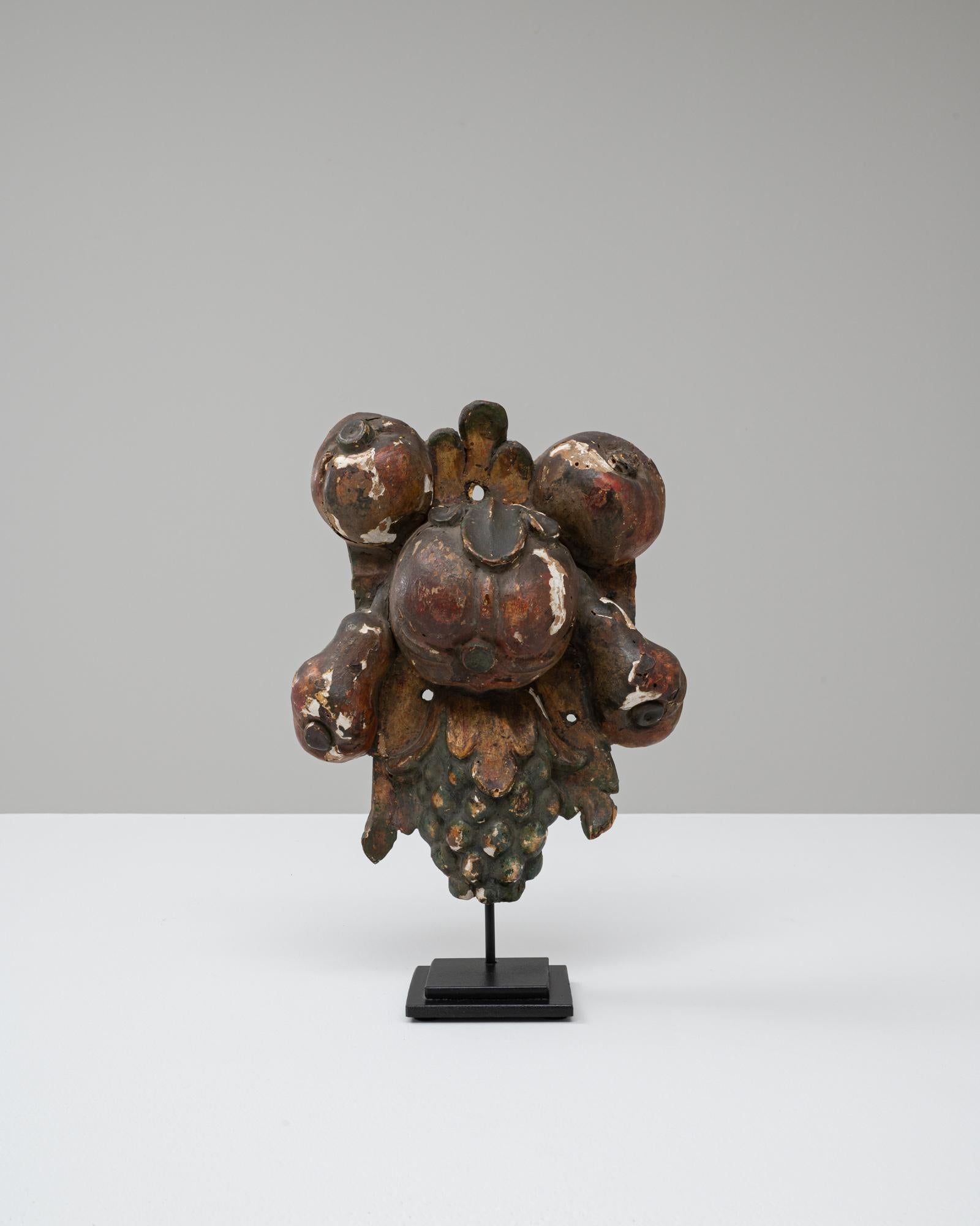 Questa decorazione barocca in legno francese del XX secolo presenta motivi di frutta riccamente scolpiti e tracce della sua finitura policroma originale, offrendo un esempio sorprendente di artigianato ornamentale. La composizione intagliata,
