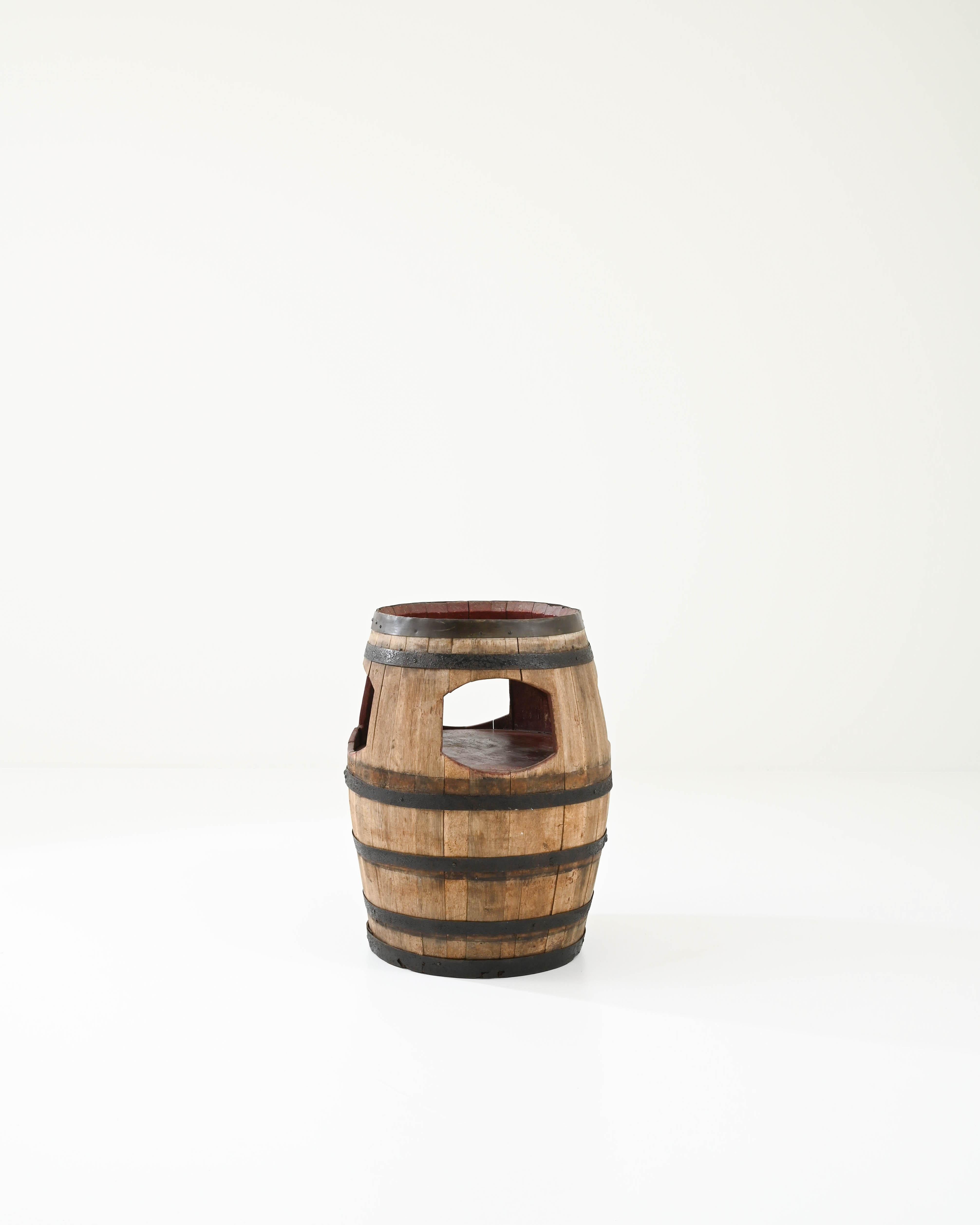 This side table was made out of an original barrel in France in the last century. Tight-grained yet flexible European oak, traditionally utilized for shaping barrels, is embraced by sound metal hoops for extra durability. A cutaway opening reveals a