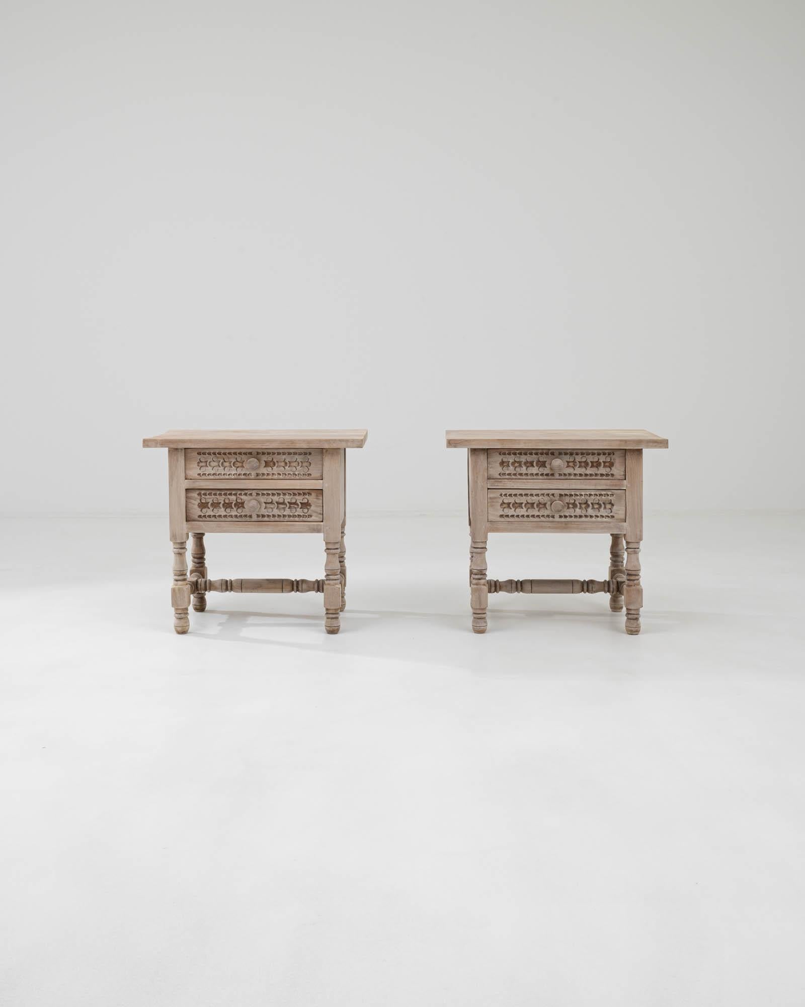 A pair of bedside tables created in 20th Century France. Full of playful character, this pair of bedtime tables radiates a soothing sense of optimistic charm. With drawer faces artfully sculpted and carved into geometric patterns and legs and