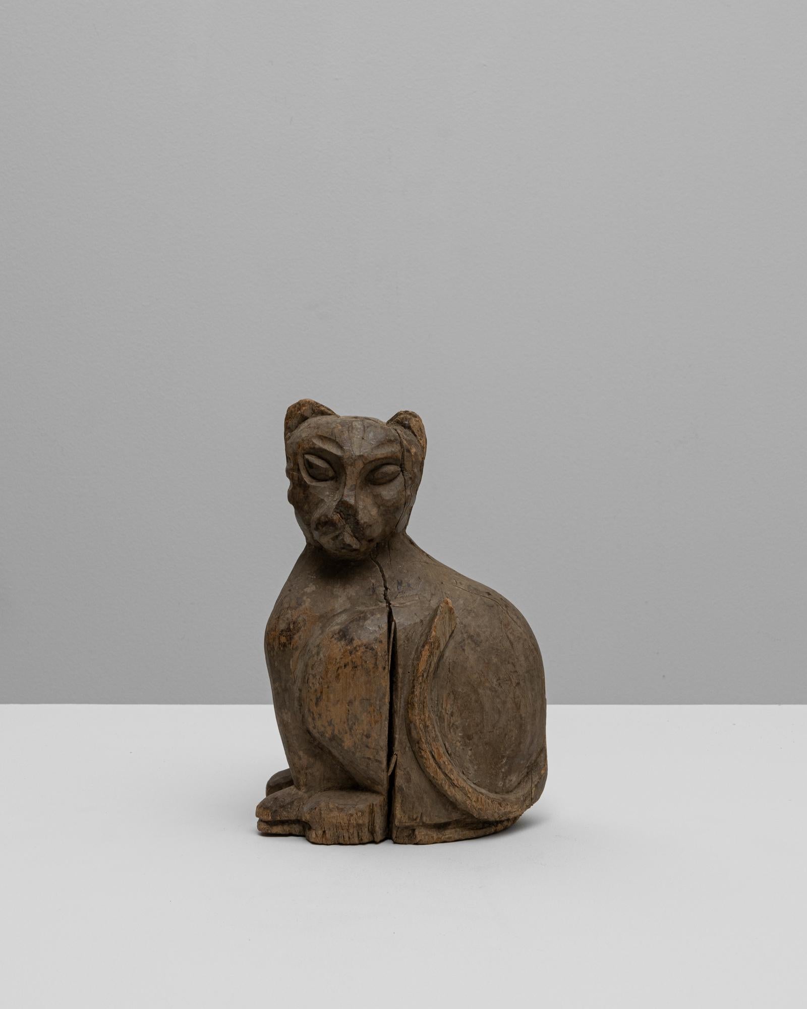 Cette sculpture de chat en bois française du XXe siècle dégage une grâce et un caractère paisibles grâce à sa forme primitive sculptée à la main. Fabriquée en bois massif, la figurine affiche une posture stylisée avec des traits simplifiés - dos