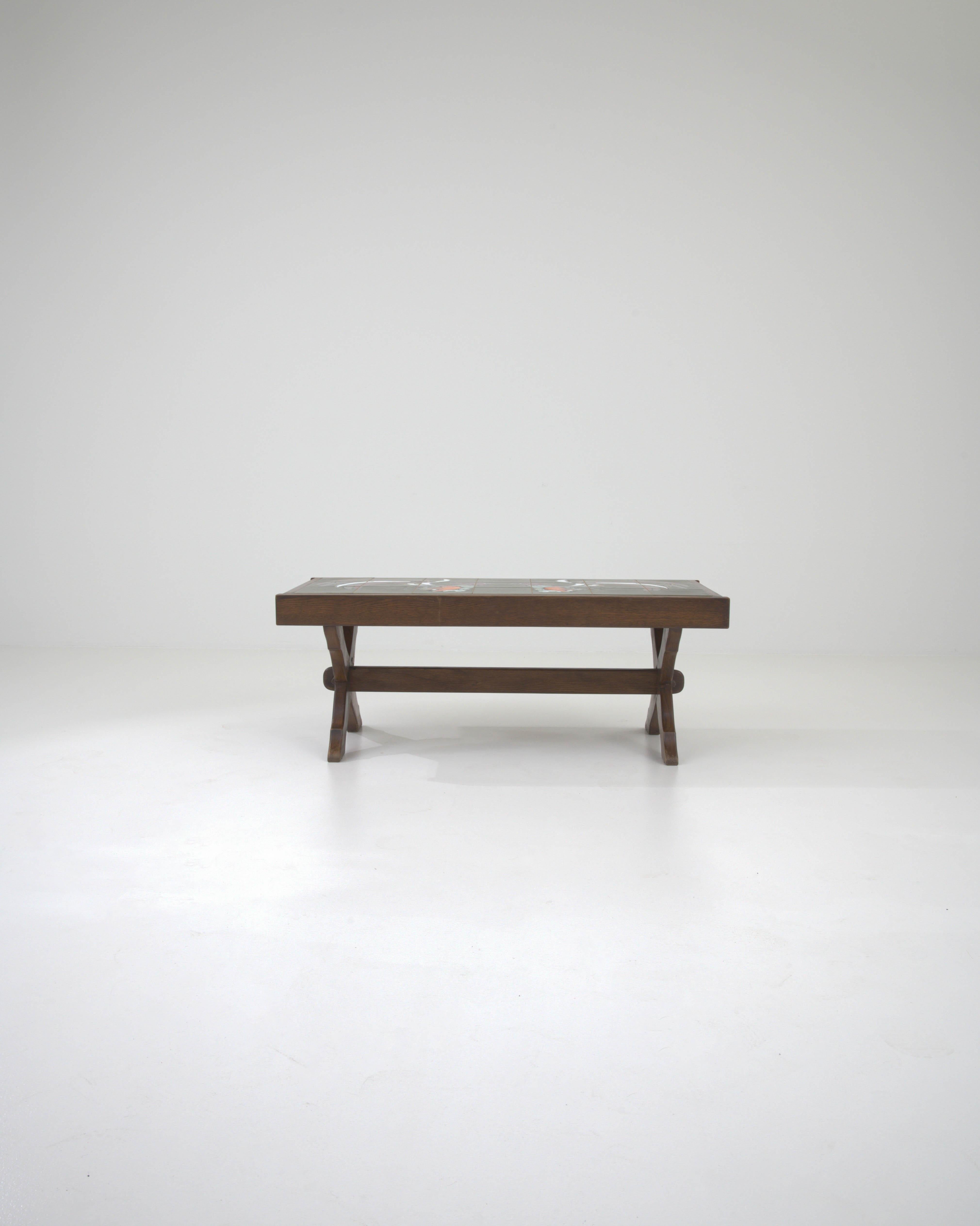 Présentant un mélange frappant de charme rustique et de flair artisanal, cette table basse en bois français du 20e siècle avec plateau en céramique est une célébration de l'artisanat traditionnel. Le cadre en bois robuste, avec sa riche finition