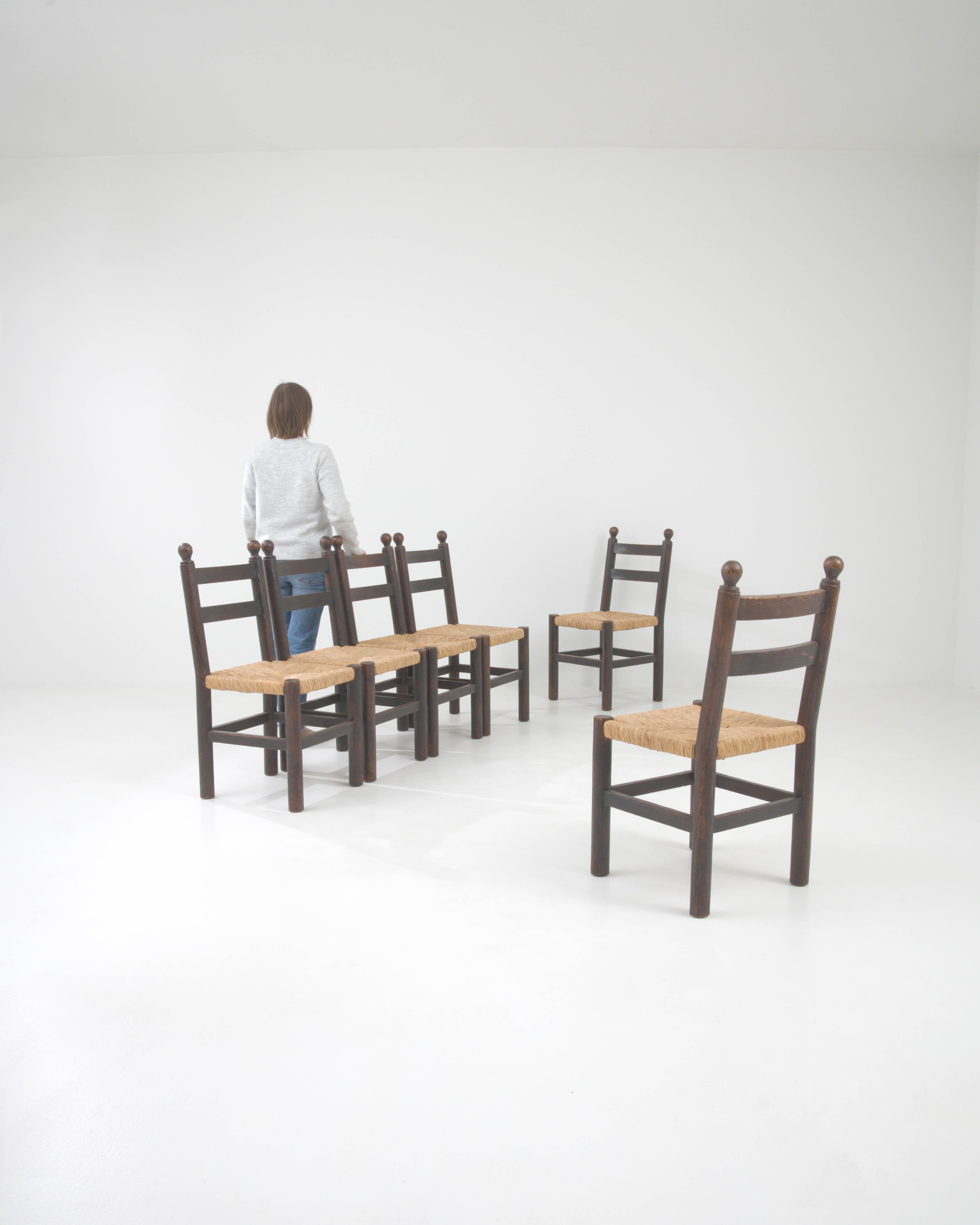 Introduisez l'essence de l'élégance campagnarde française dans votre salle à manger avec cet ensemble de six chaises de salle à manger en bois du 20e siècle. Ces pièces intemporelles offrent un mélange harmonieux de style traditionnel et de confort,
