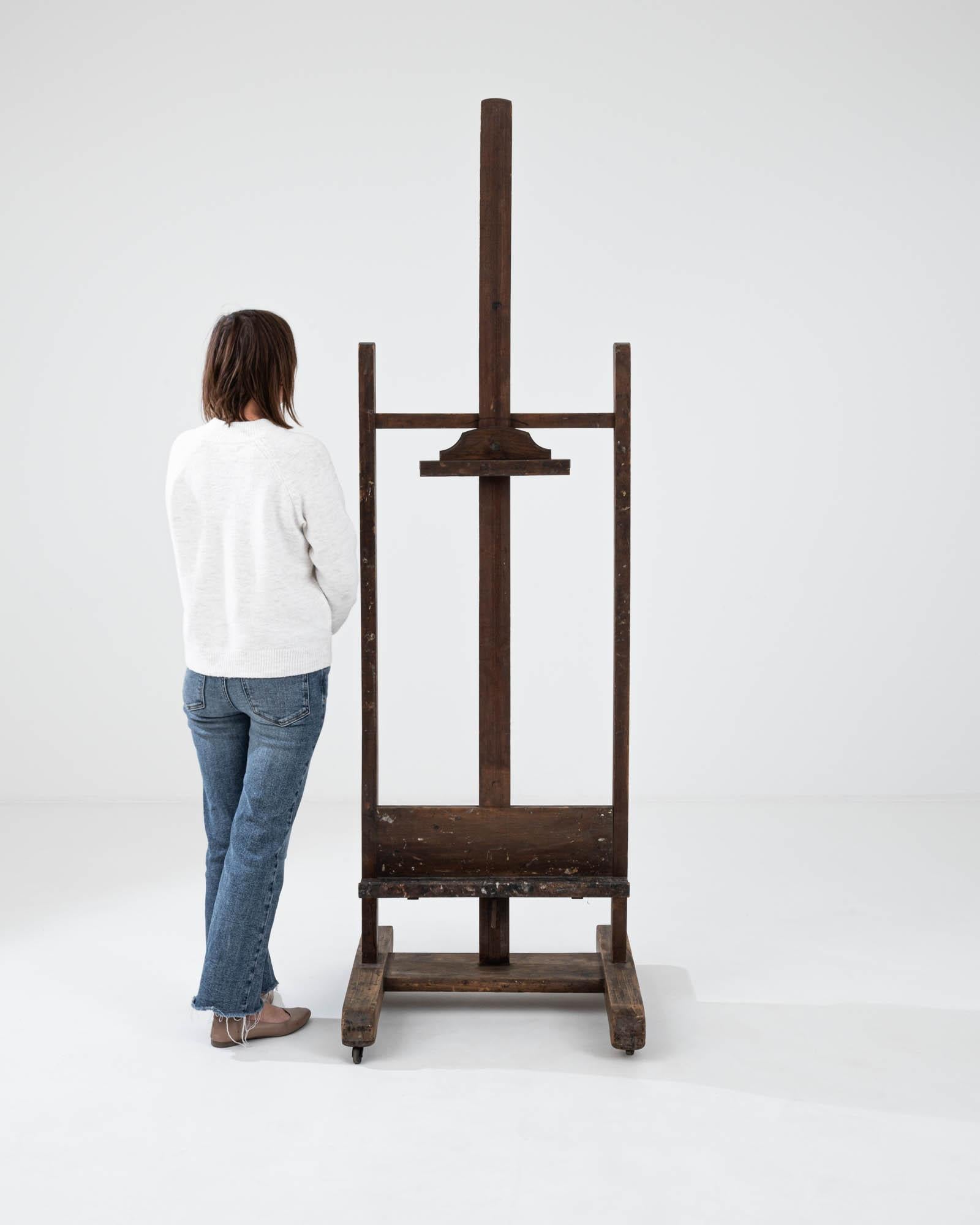 This wooden easel provides a bohemian accent or a practical accessory with a nostalgic touch. A wooden easel made in France circa 1900, standing upright with a composed posture, this adjustable easel is ready for its next job. Warm, glowing mood