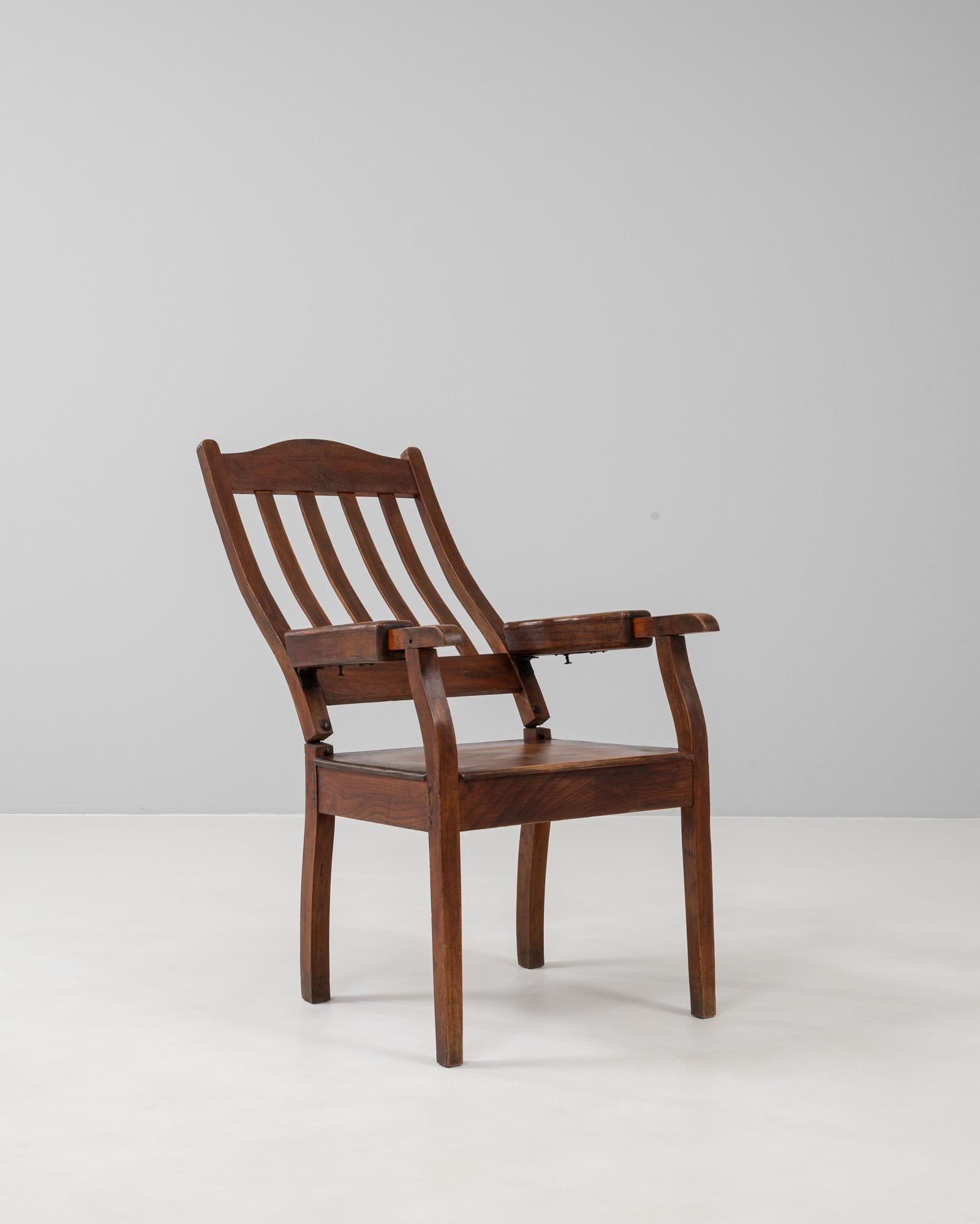 Questa poltrona pieghevole in legno francese del XX secolo incarna sia l'artigianato che la funzionalità. Realizzato in legno massiccio con una patina calda e ricca, presenta uno schienale a doghe graziosamente curvato e braccioli robusti, che