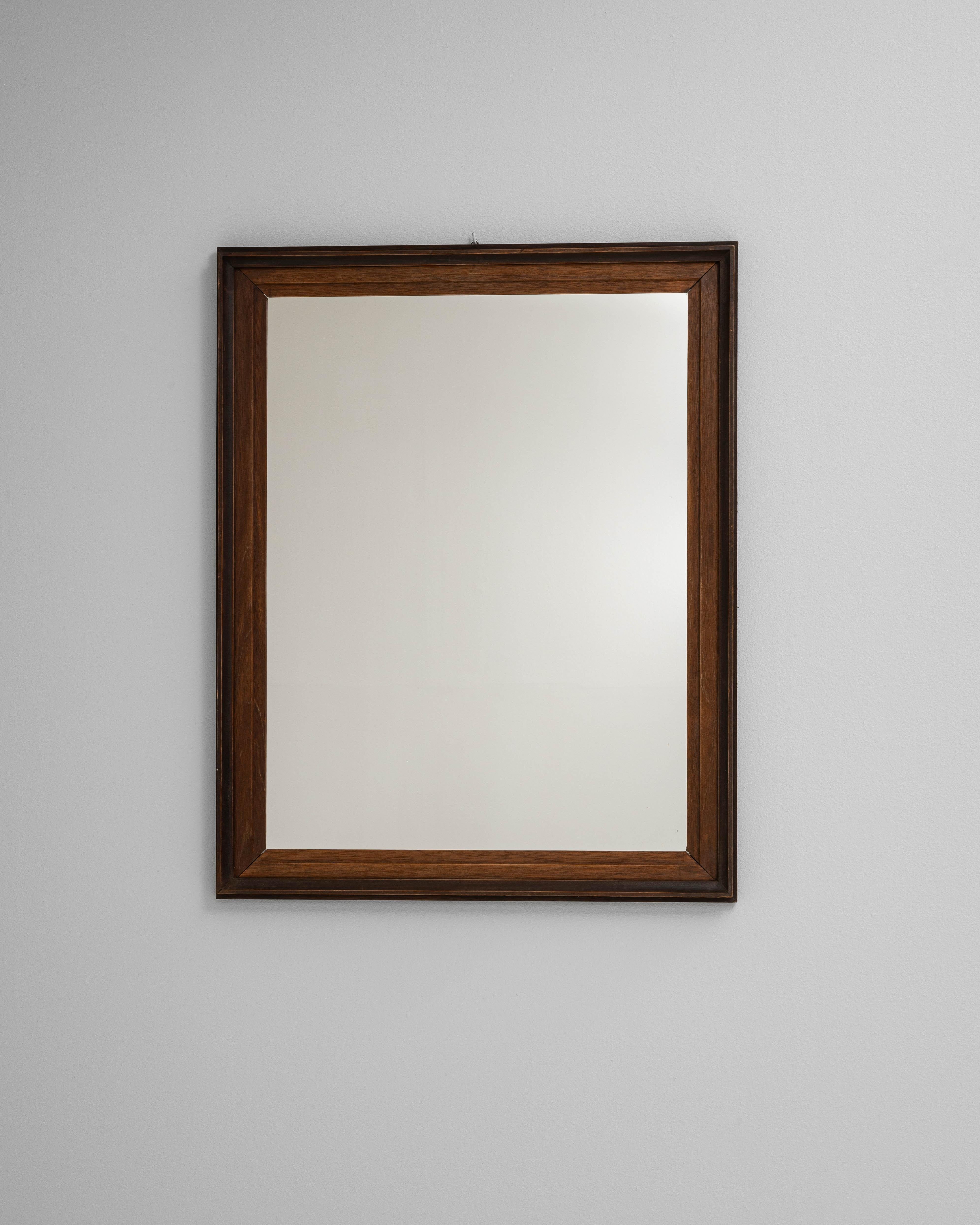 Questo specchio in legno francese del XX secolo presenta una classica forma quadrata incorniciata in un ricco legno tinto di scuro con un bordo interno smussato. Il design è minimale e senza tempo, permettendo alle venature naturali del legno di