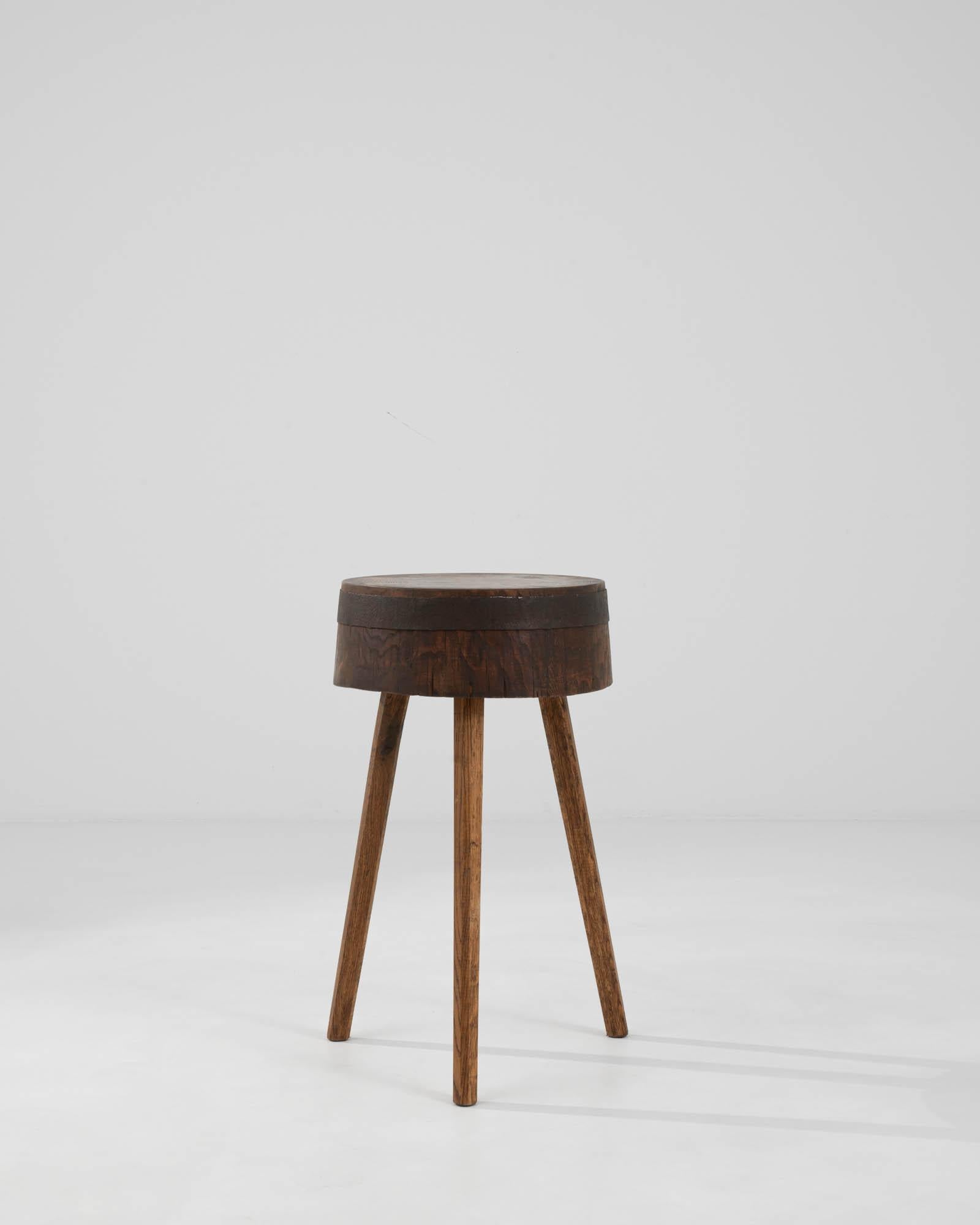 This 20th Century French Wooden Side Table exudes timeless elegance and understated sophistication. Its smooth, round top showcases the rich, deep hues of well-aged wood, bearing the gentle hallmarks of history in its subtle grain patterns and warm