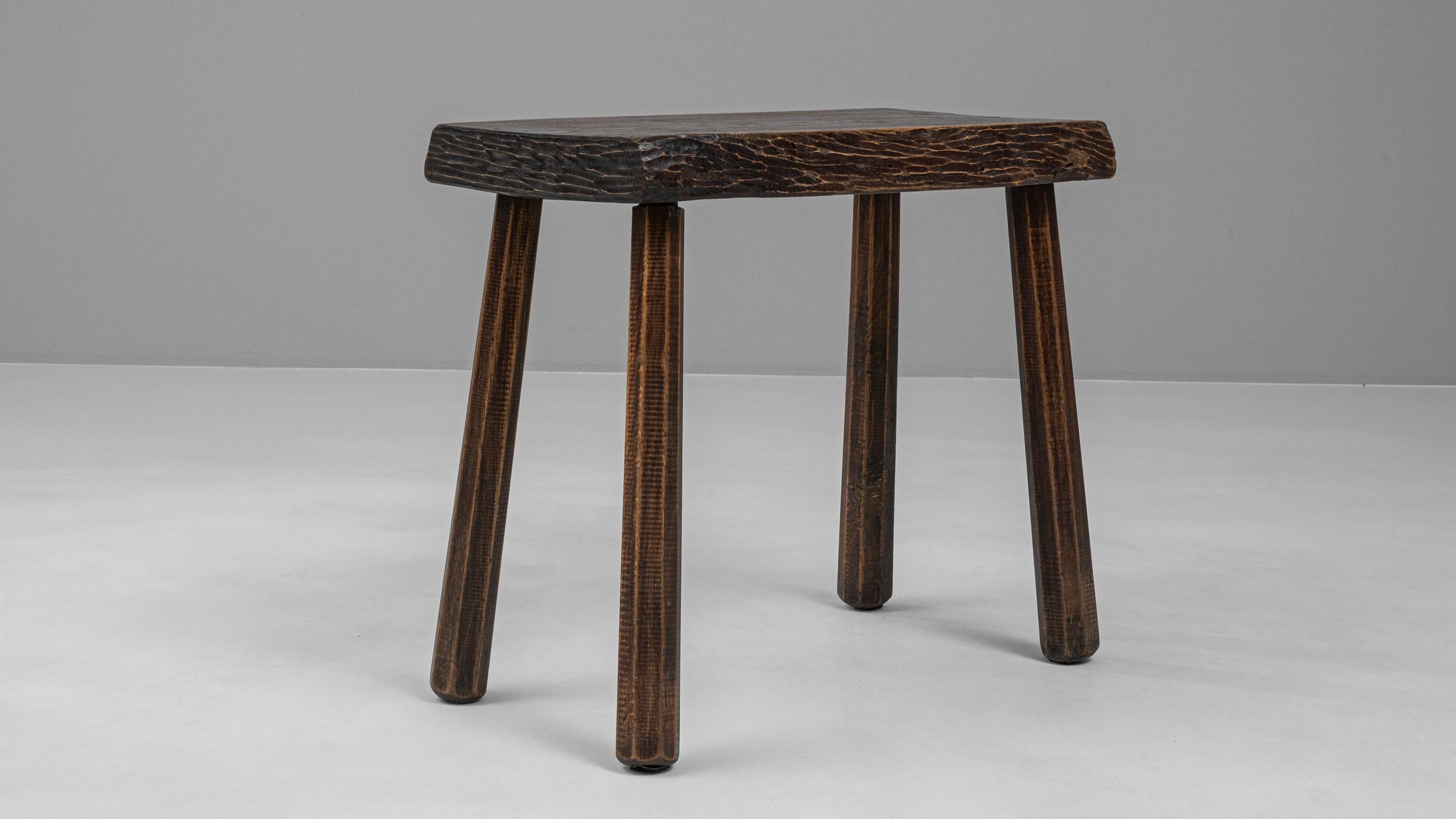 Embrace the rustic allure of this 20th Century French Wooden Side Table, a piece that encapsulates both functionality and the warmth of traditional craftsmanship. This charming side table, with its rich, deep wood tones and distinctive grain