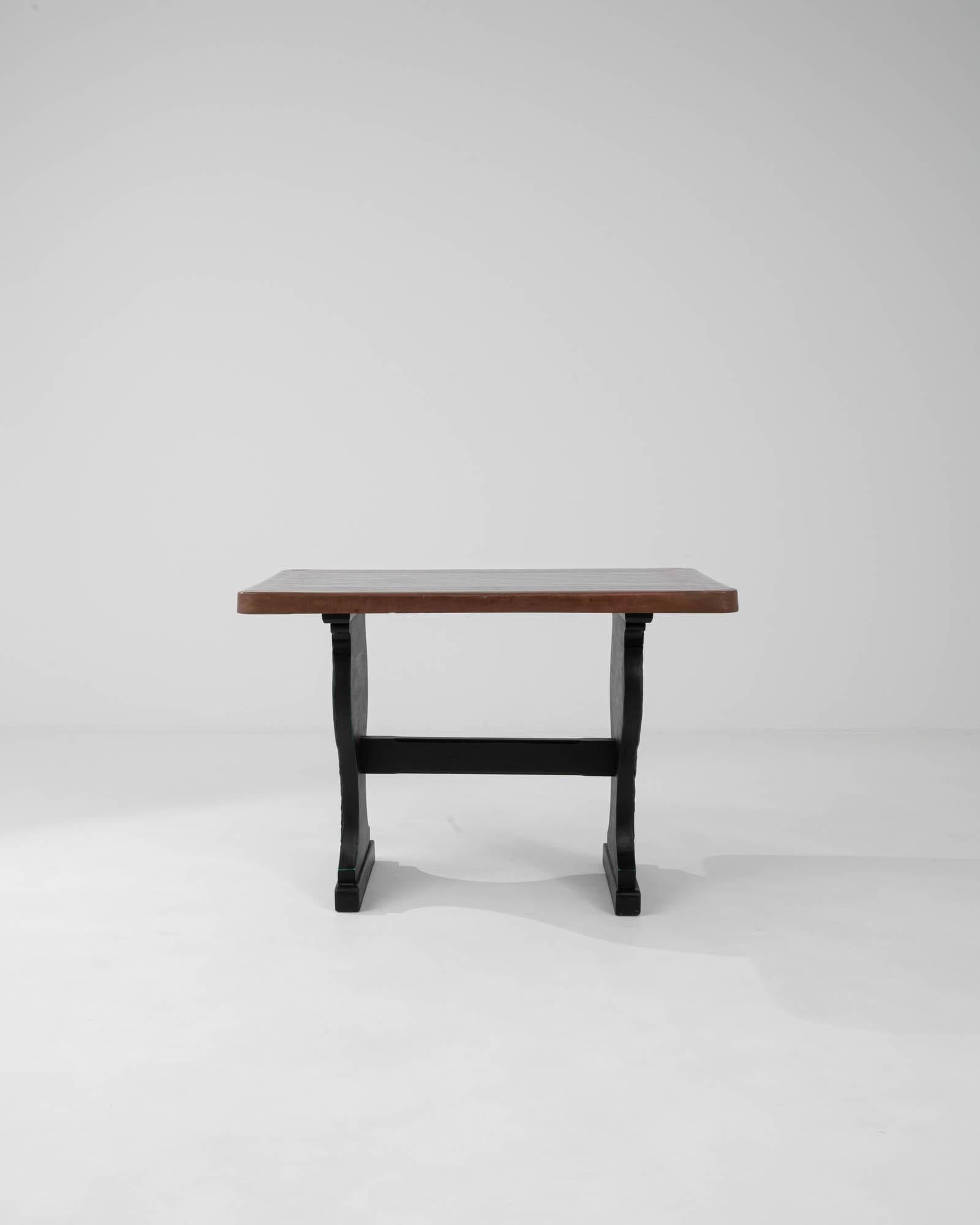 Añade un toque de refinada elegancia a tu hogar con esta Mesa de Madera Francesa del Siglo XX. Con una base negra, rica e intrincadamente tallada que añade un elemento de sofisticación y arte, esta mesa es perfecta para quienes aprecian la artesanía