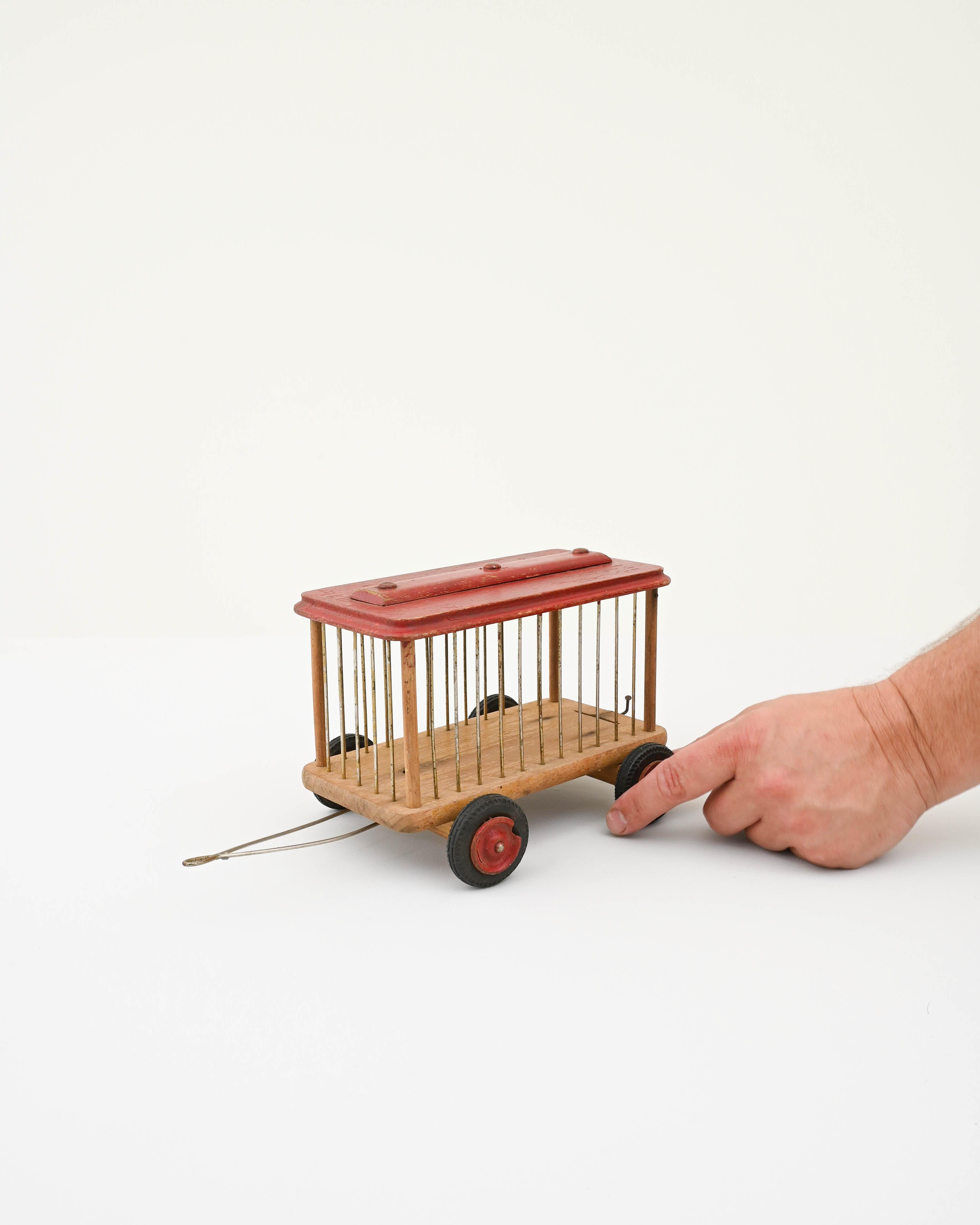 Transport yourself back in time with this charming 20th-century French Wooden Toy Car—a delightful creation that echoes the simplicity and charm of vintage playthings. Crafted with care, this wooden car takes the form of a whimsical cage on wheels,