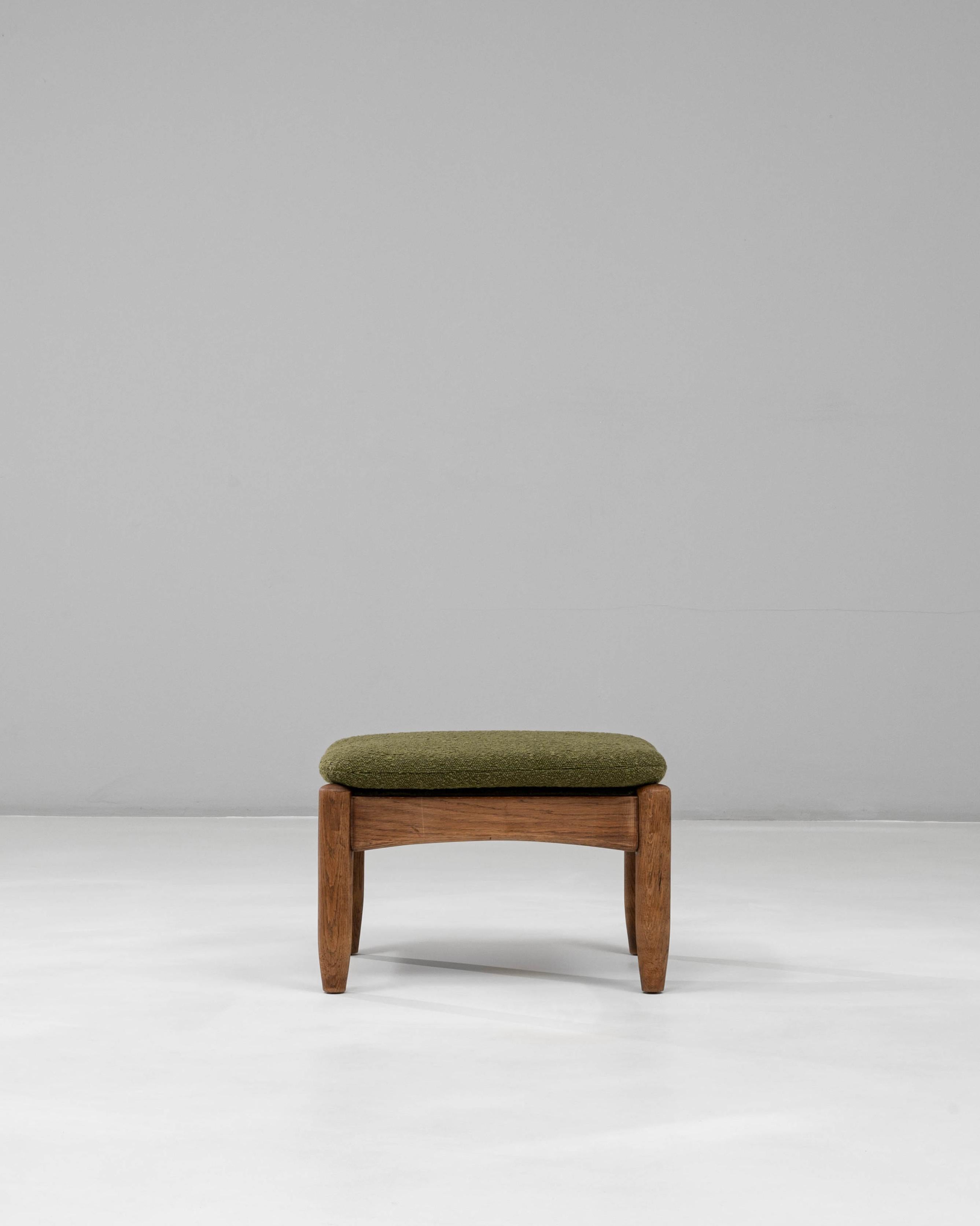 Ce pouf en bois français du 20e siècle présente une silhouette chaleureuse et organique qui reflète l'élégance discrète de l'artisanat du milieu du siècle. Le cadre en bois massif est façonné avec des bords doucement arrondis et des pieds légèrement