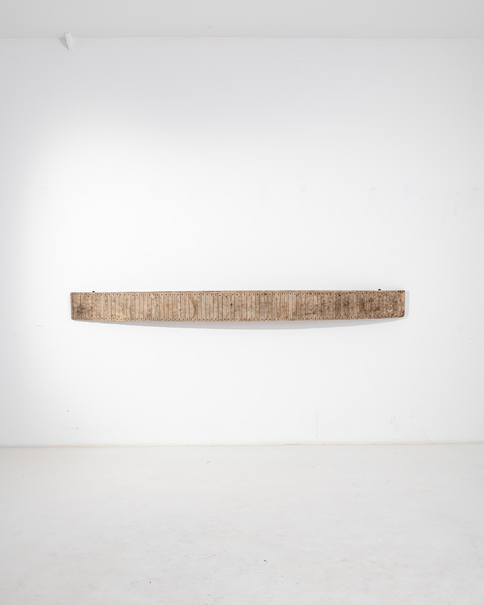 The unique design of this vintage wooden wall console merges a clean minimalist shape with rustic materials. Made in France in the 20th century, a solid slice of wood protrudes from the wall in a streamlined curve, forming a narrow shelf. The outer