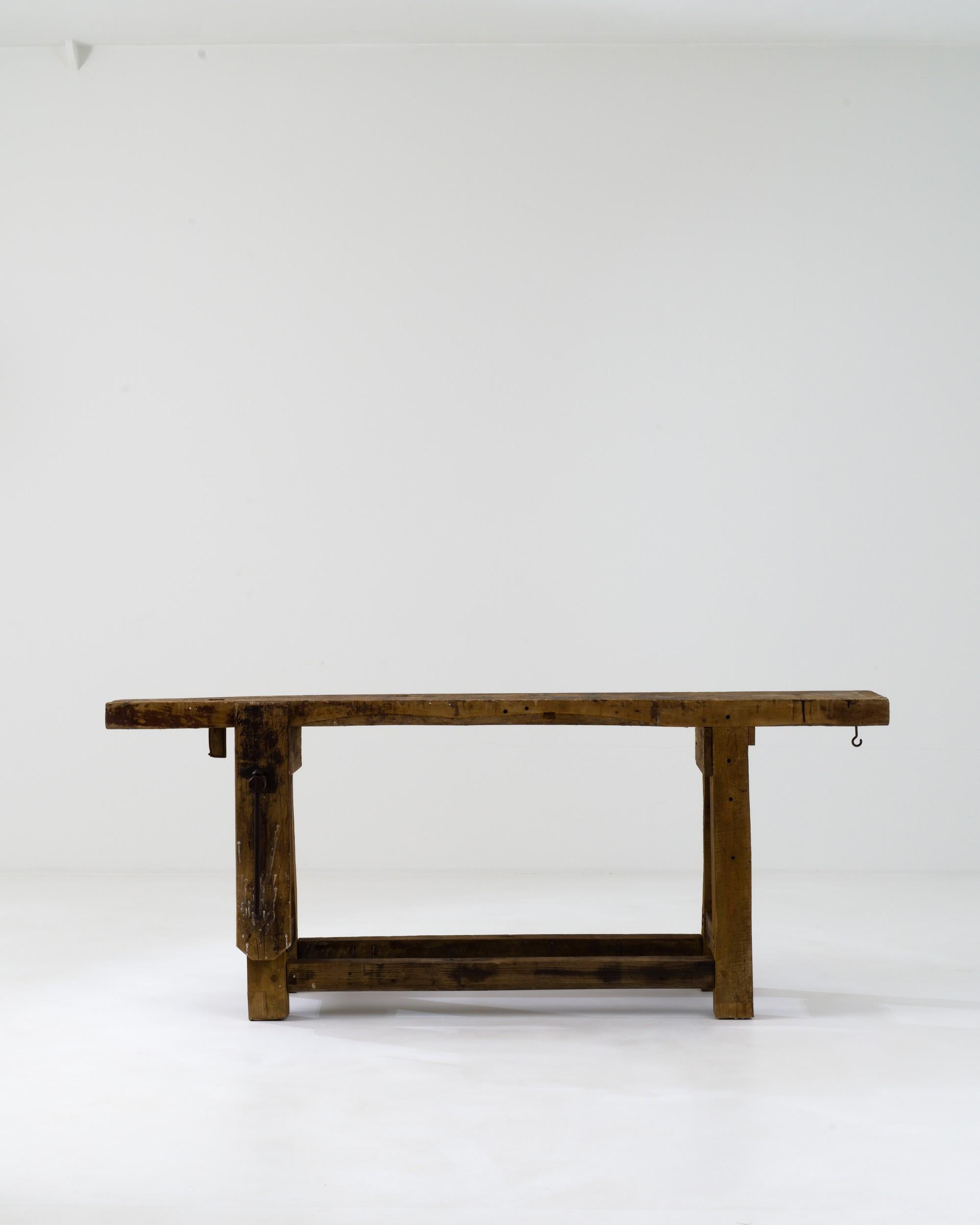 Bearing the marks of numerous artisanal projects, this authentic worktable was crafted in France during the 20th century. Its rectangular top rests on sturdy A-shaped legs, offering a spacious and robust workspace. Several metal details, such as a