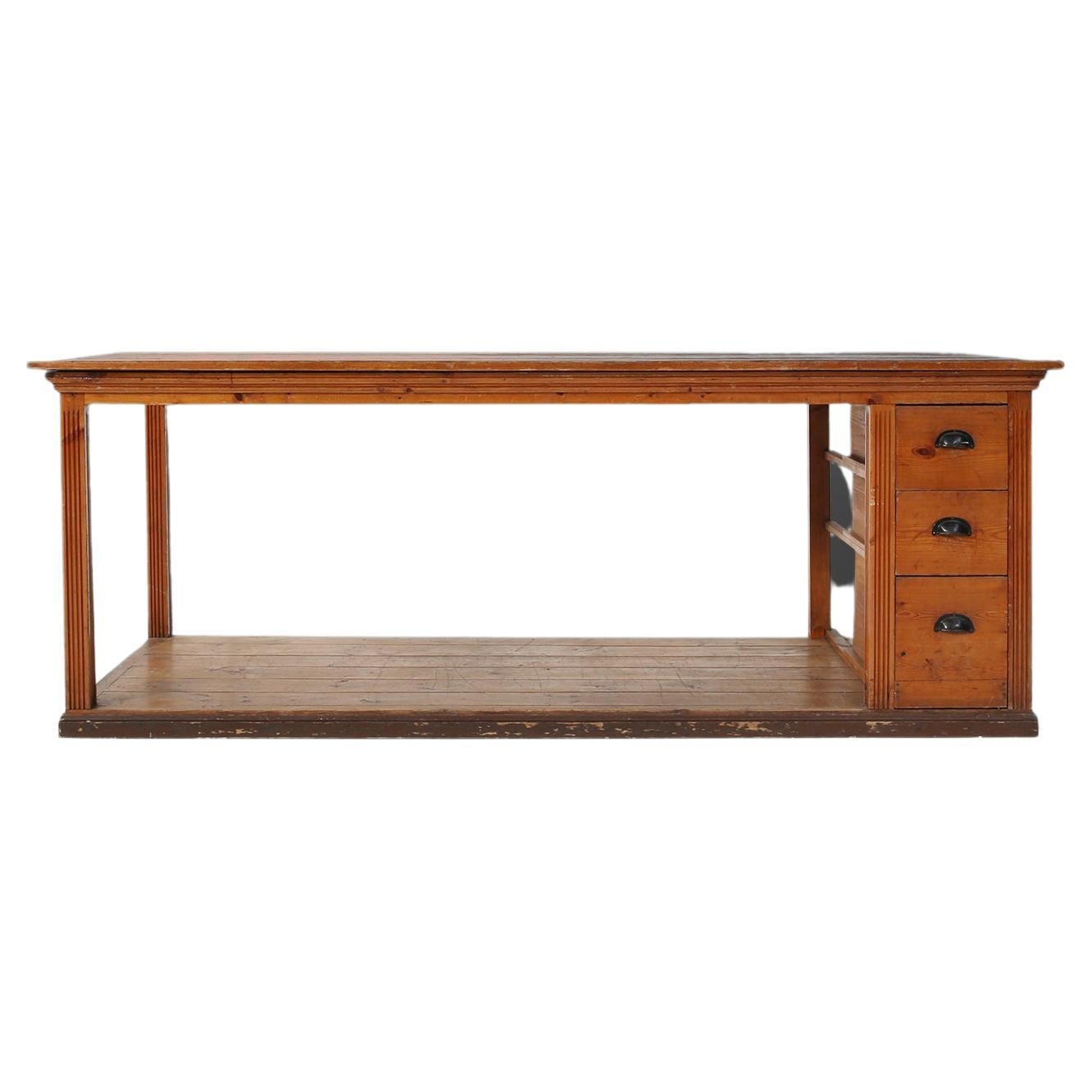 French working table in pine wood made around 1920. A large wooden table with great patina on the wood. The sturdy frame is finished with a practical bottom shelf and three drawers on the right side for a perfect storage space.

These tables were