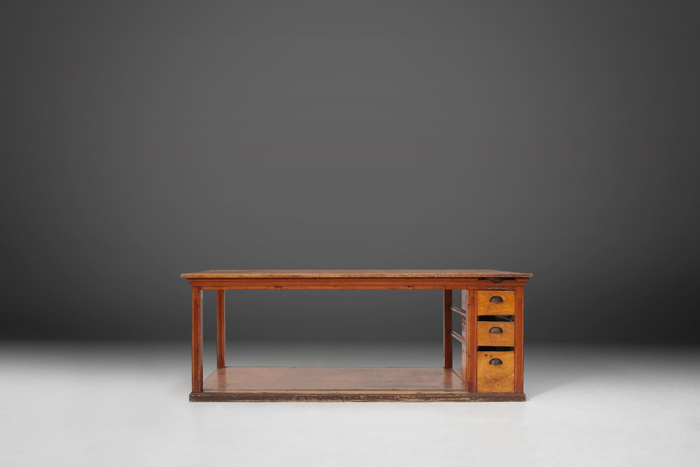 Französischer Arbeitstisch aus Kiefernholz, hergestellt um 1920. Ein großer Holztisch mit toller Patina auf dem Holz. Das robuste Gestell ist mit einem praktischen Boden und drei Schubladen auf der rechten Seite ausgestattet, die einen perfekten