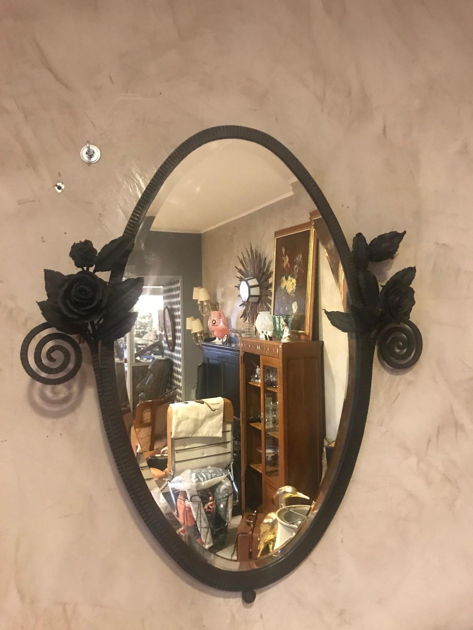 Beautiful 20th century French wrought iron and beveled glass mirror with very nice roses wrought iron decoration on each sides of the mirror from the 1925.
Stunning oval shape. Very good quality and condition.