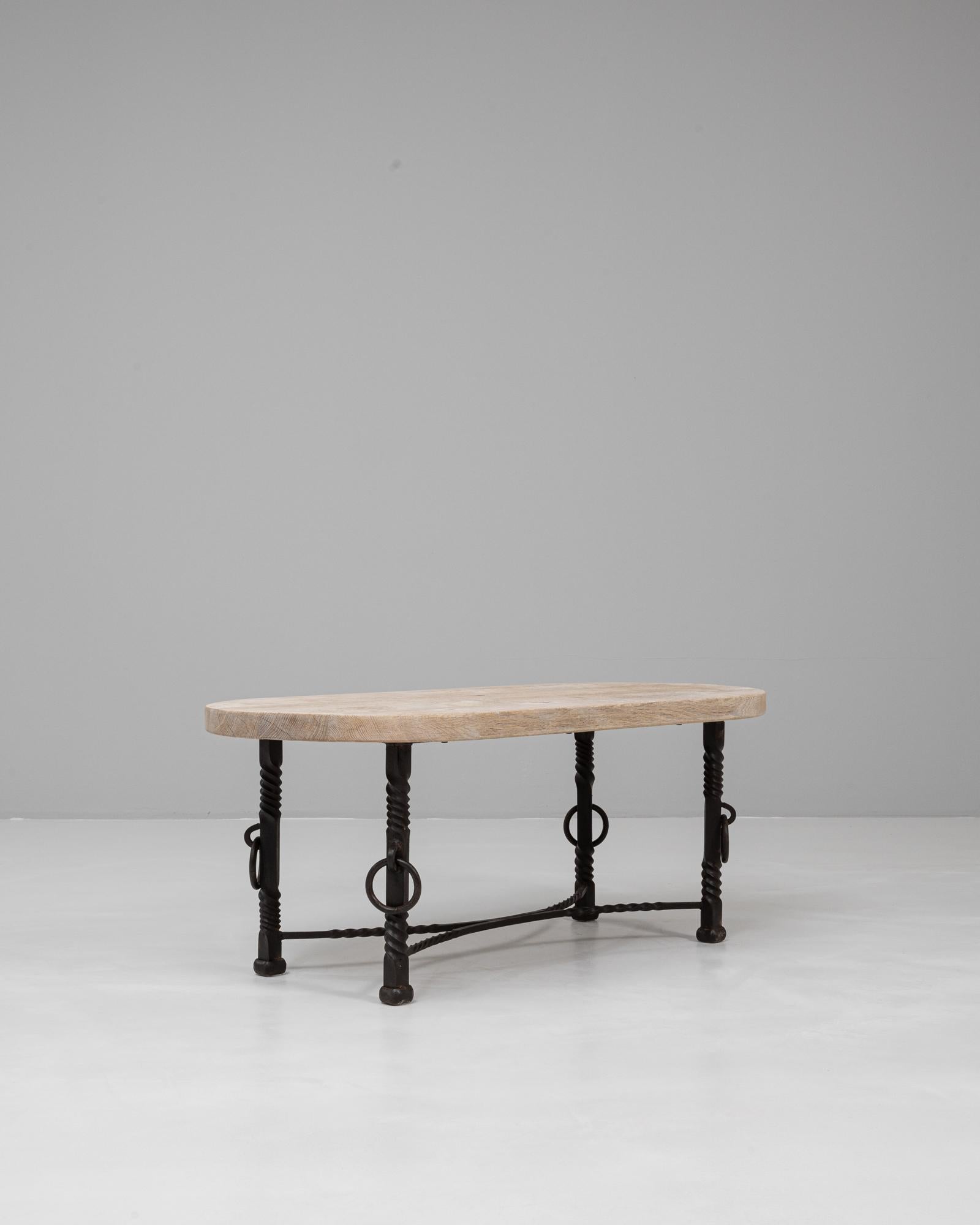 Esta mesa baja francesa de hierro forjado del siglo XX con tapa de roble combina el encanto rústico con la artesanía perdurable. La encimera de roble macizo presenta un acabado natural que resalta sus vetas, aportando calidez y carácter a la pieza.