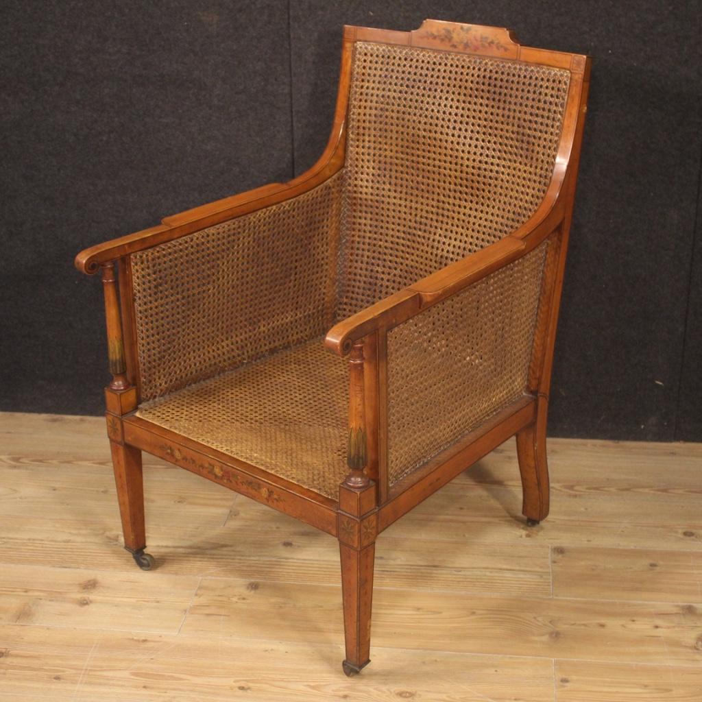 English armchair from the early 20th century. Furniture carved in fruitwood with high quality hand painted geometric and floral decorations. Armchair of beautiful line and pleasant decor richly adorned with cane on the front, seat and sides. Cane