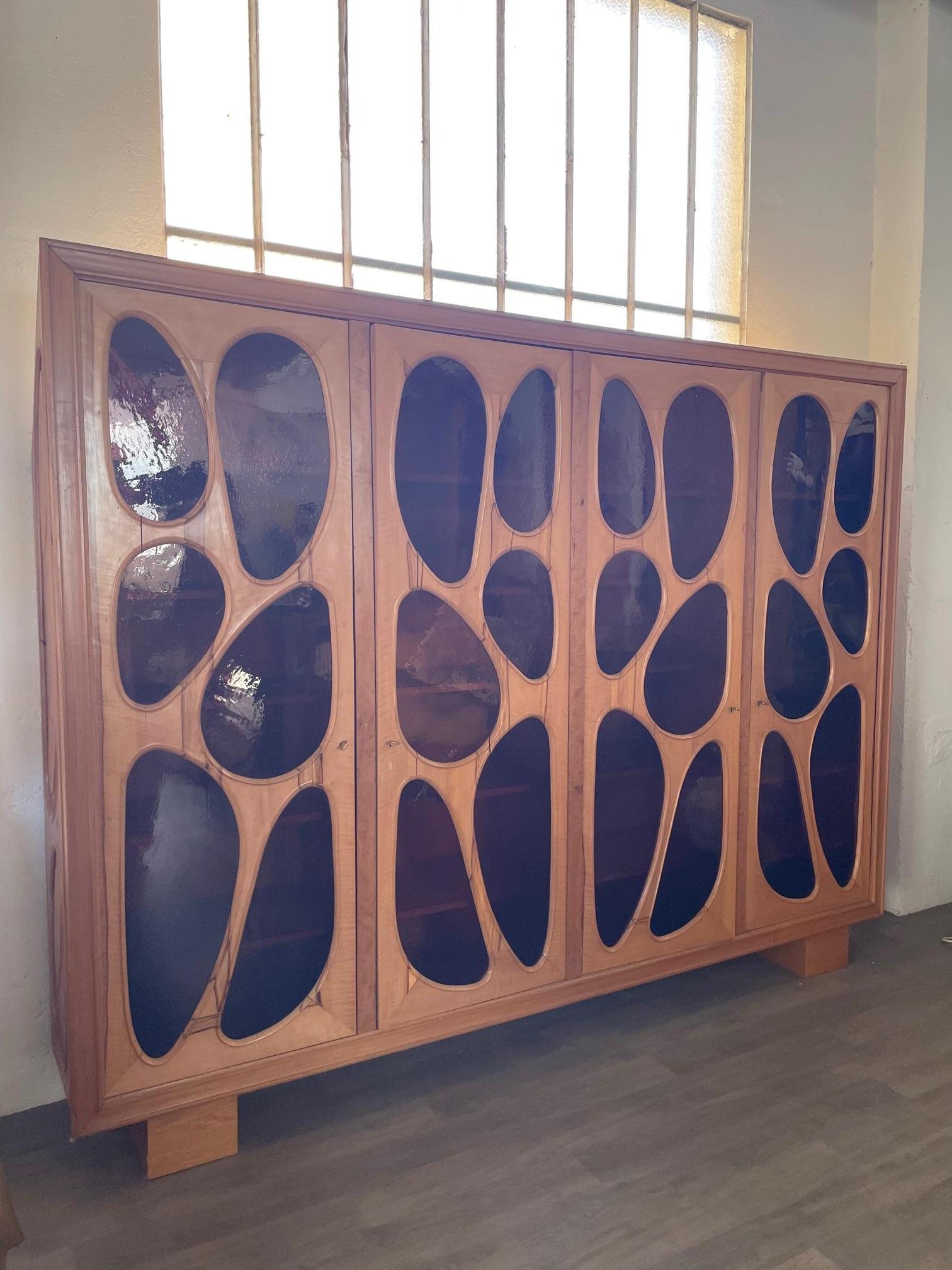 Exceptional and made in one copy fruitwood bibliothèque/vitrine by Vincent Gonzalez with original shape glass doors. The shape of this vitrine is rare, it has been made tailored to fit a place under a roof so the back is made sloping. 
The glass