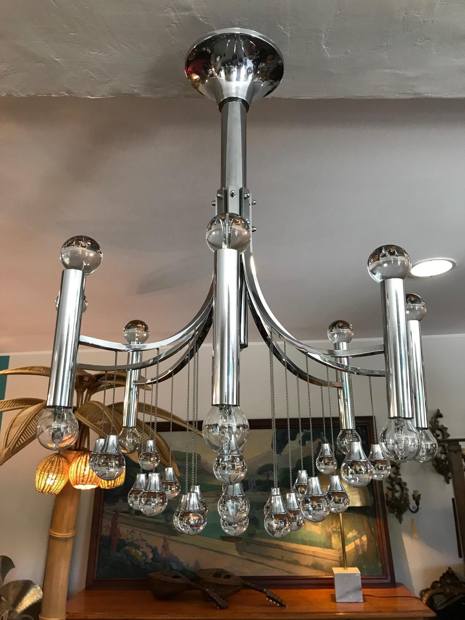 Chandelier, 1970s design, structure in chrome-plated stainless steel, on the lower part there are sphere-shaped crystals hanging from chains and 8 rods with small light points, on the upper part of these chrome-plated lamp holders there are other