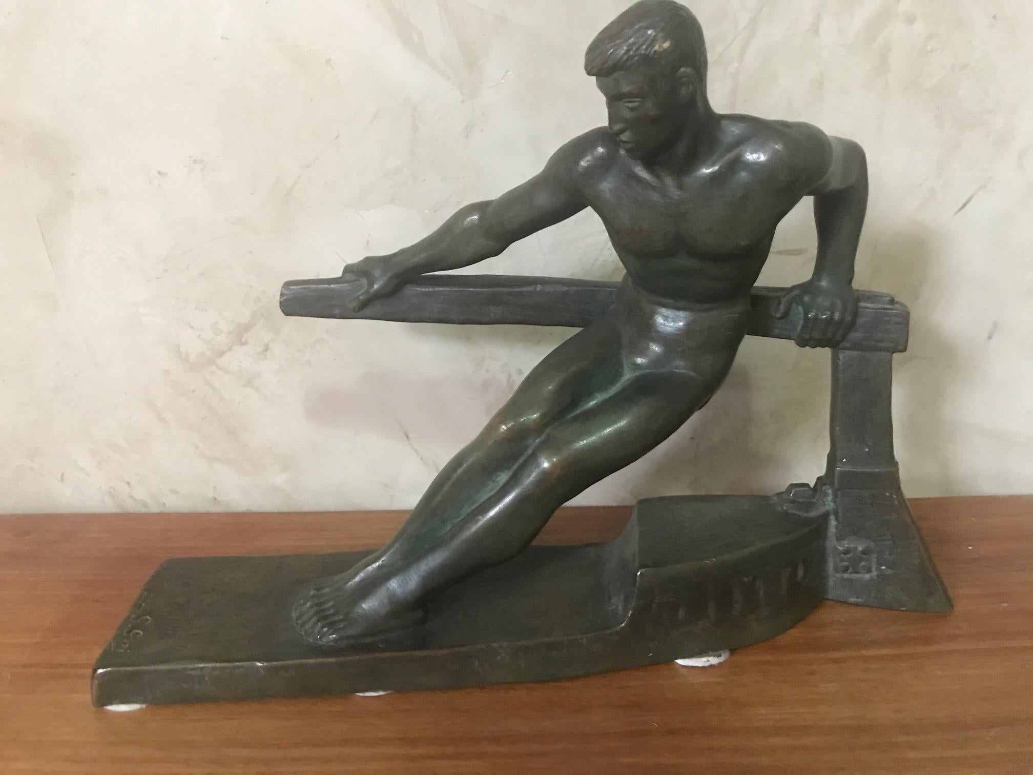 An Art Deco bronze sculpture by Georges Gori, depicting a man on a base that hints that it is a boat and he is pushing against a tiller to work the rudder against the power of the sea. There is exceptional detail in his face, hands and the