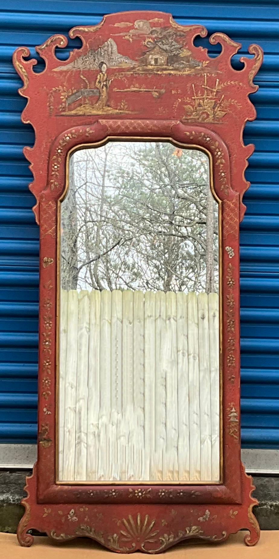 This is a lovely hand painted chinoiserie mirror with Georgian styling. It depicts hand painted pastoral scenes on a Chinese red background. The frame is wood and unmarked. It is believed to be Italian.