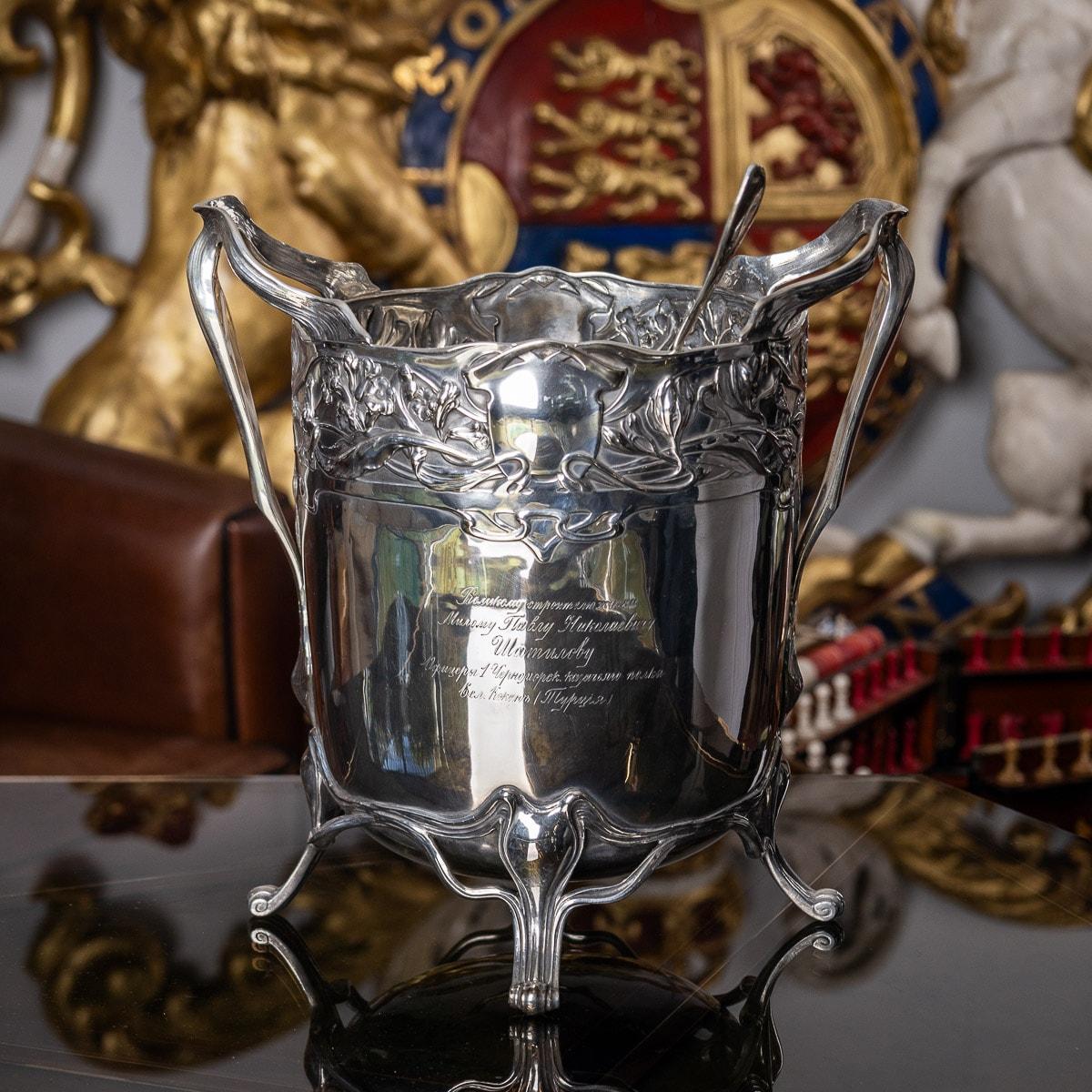 20th century German Art Nouveau silver large punch bowl and ladle, the bowl raised on four spreading scroll feet, decorated throughout with floral motifs and applied with unusual flowing handles. Engraved in Cyrillic on one side “To the great