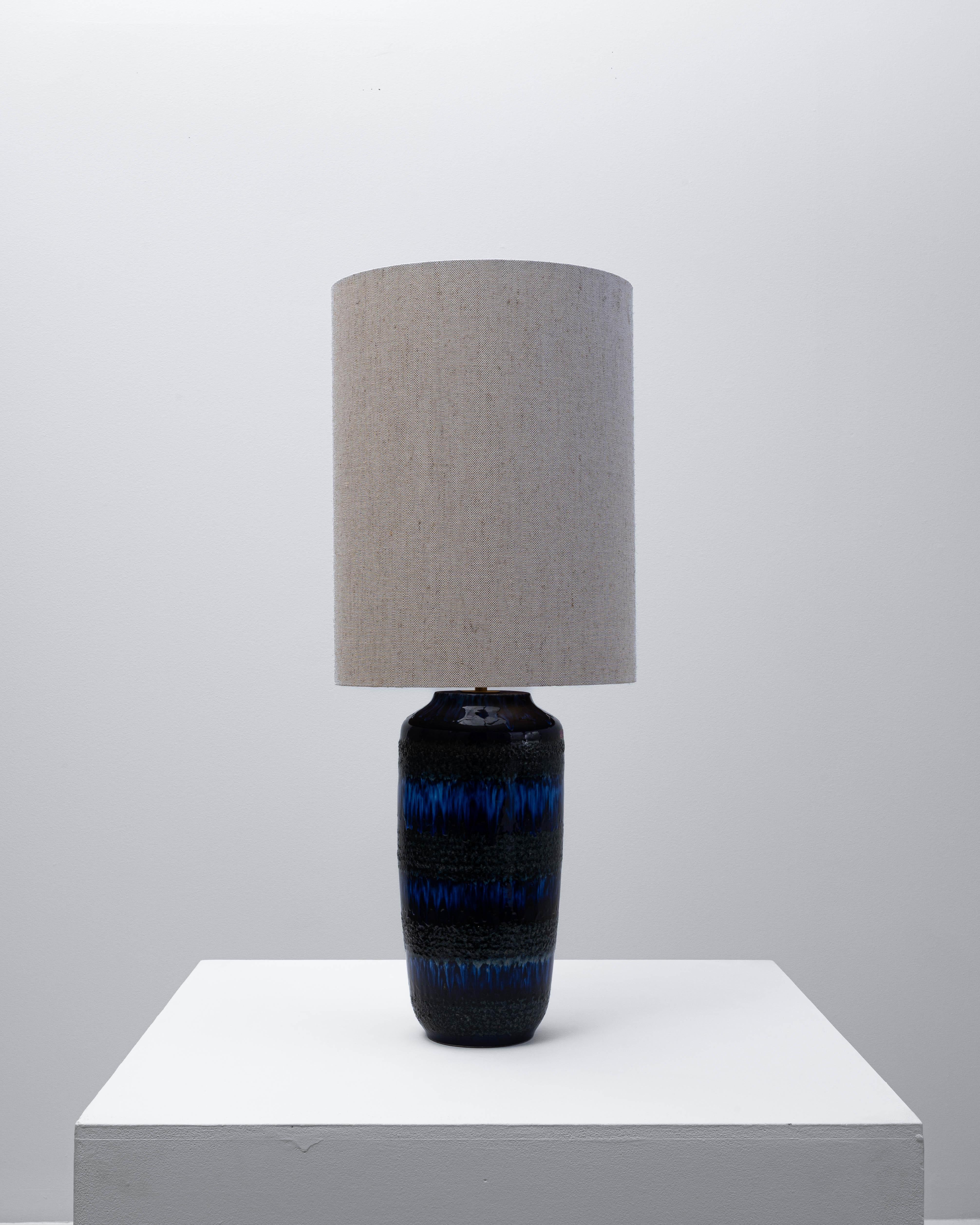 20th century German blue and black lava ceramic table lamp, a striking example of the “Fat Lava” style that defined West German ceramics of the mid-century era. The textured glaze features deep cobalt and inky black tones that flow organically,