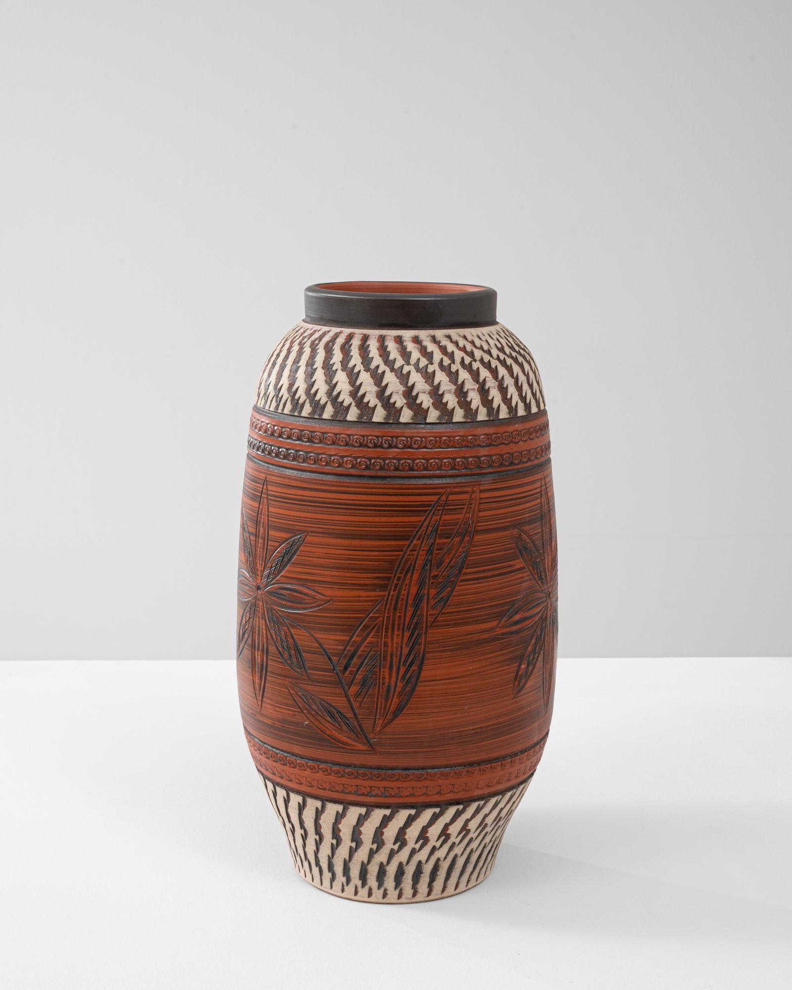 Cette cruche en céramique allemande du XXe siècle présente un mélange complexe de motifs floraux sculptés et de motifs géométriques, mettant en valeur l'art et la précision de la poterie européenne du milieu du siècle. Le corps du récipient aux tons