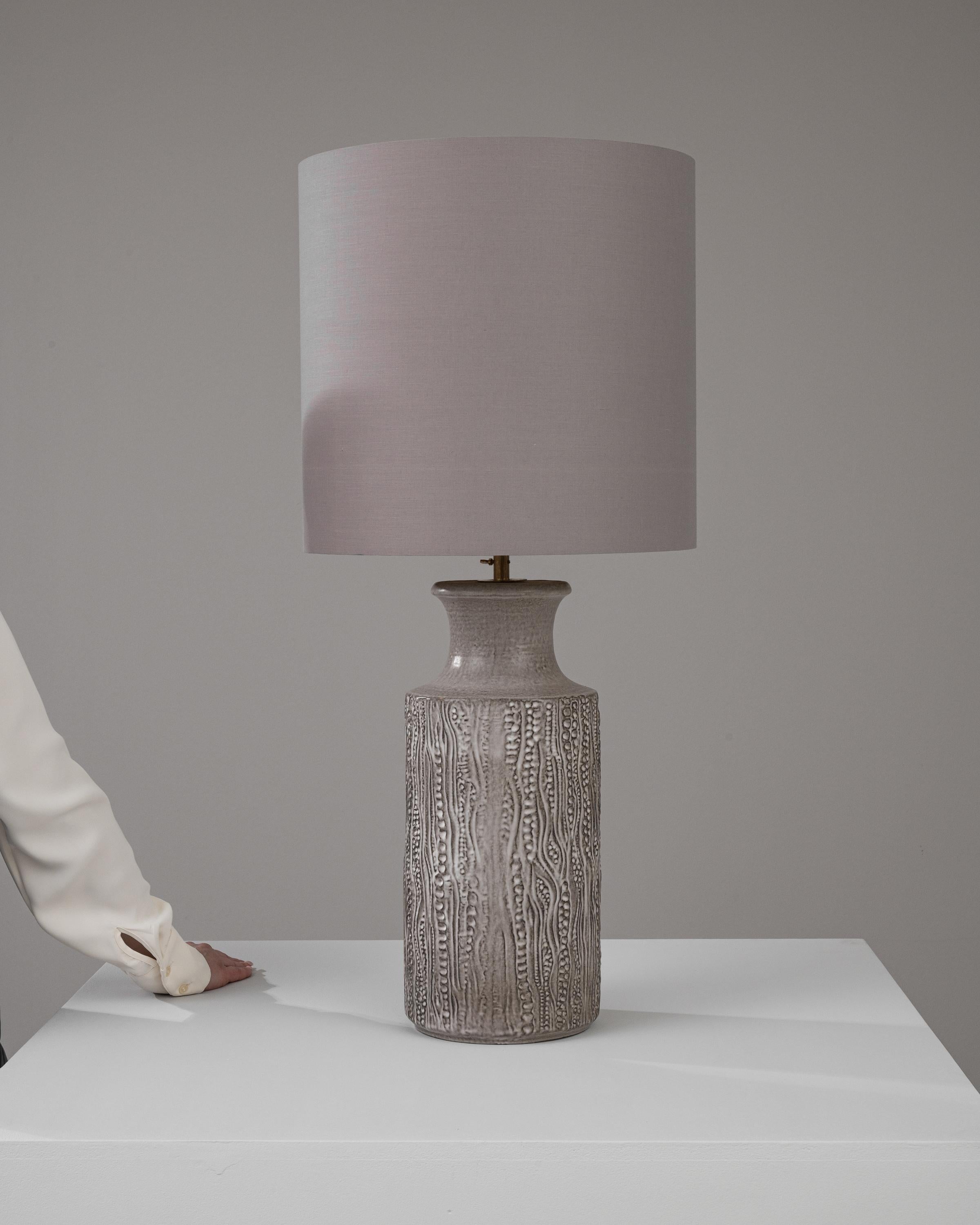 Holen Sie sich ein Stück deutsches Design des 20. Jahrhunderts in Ihr Zuhause mit dieser charaktervollen Keramik-Tischlampe, die mit einem malerischen seitlichen Griff ausgestattet ist und sowohl ästhetischen Charme als auch praktischen Nutzen