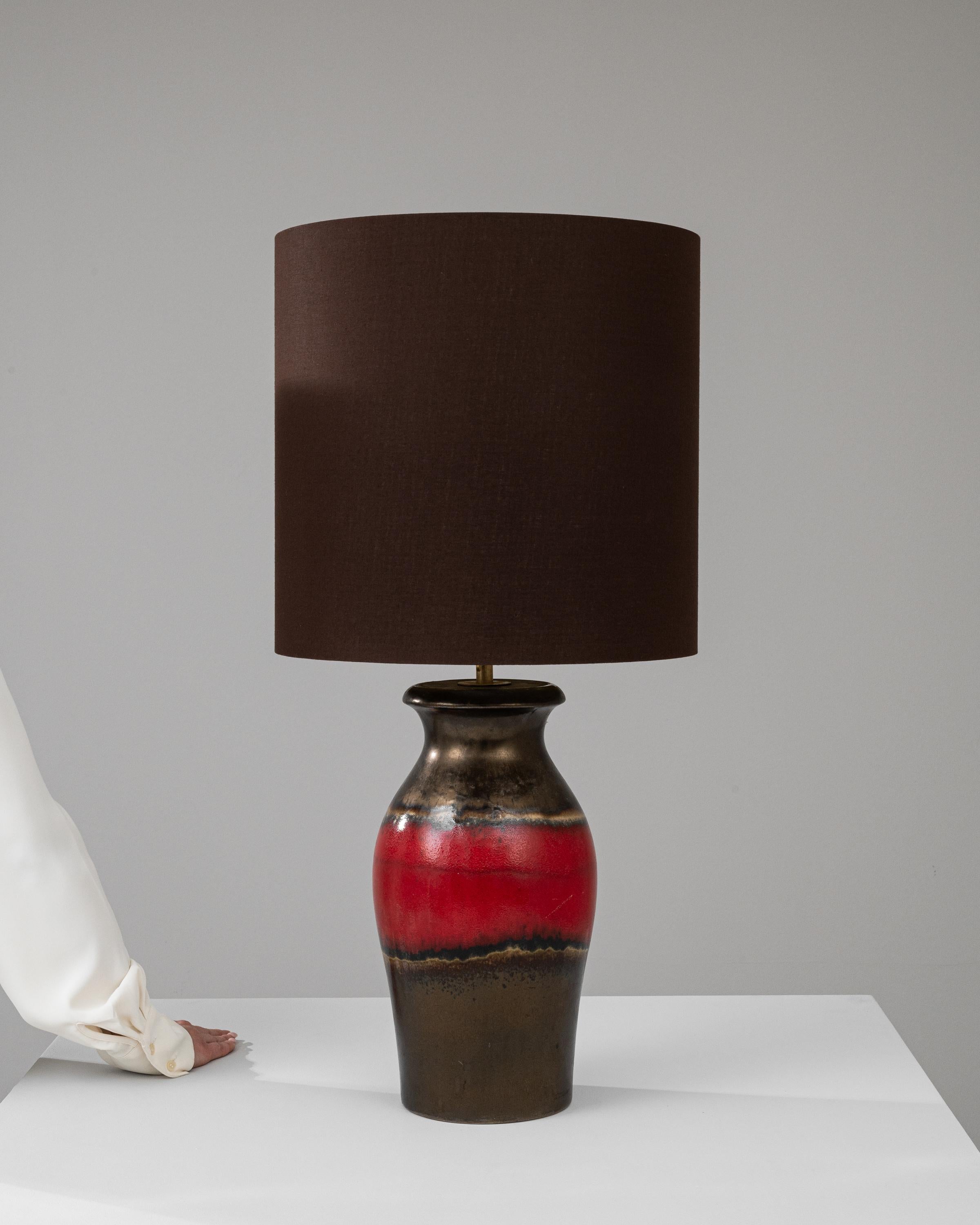 Discover the understated elegance of this 20th Century German Ceramic Table Lamp, a piece where minimalist design meets a touch of drama. The sleek, richly hued lampshade sets a sophisticated tone, perfect for both contemporary and traditional