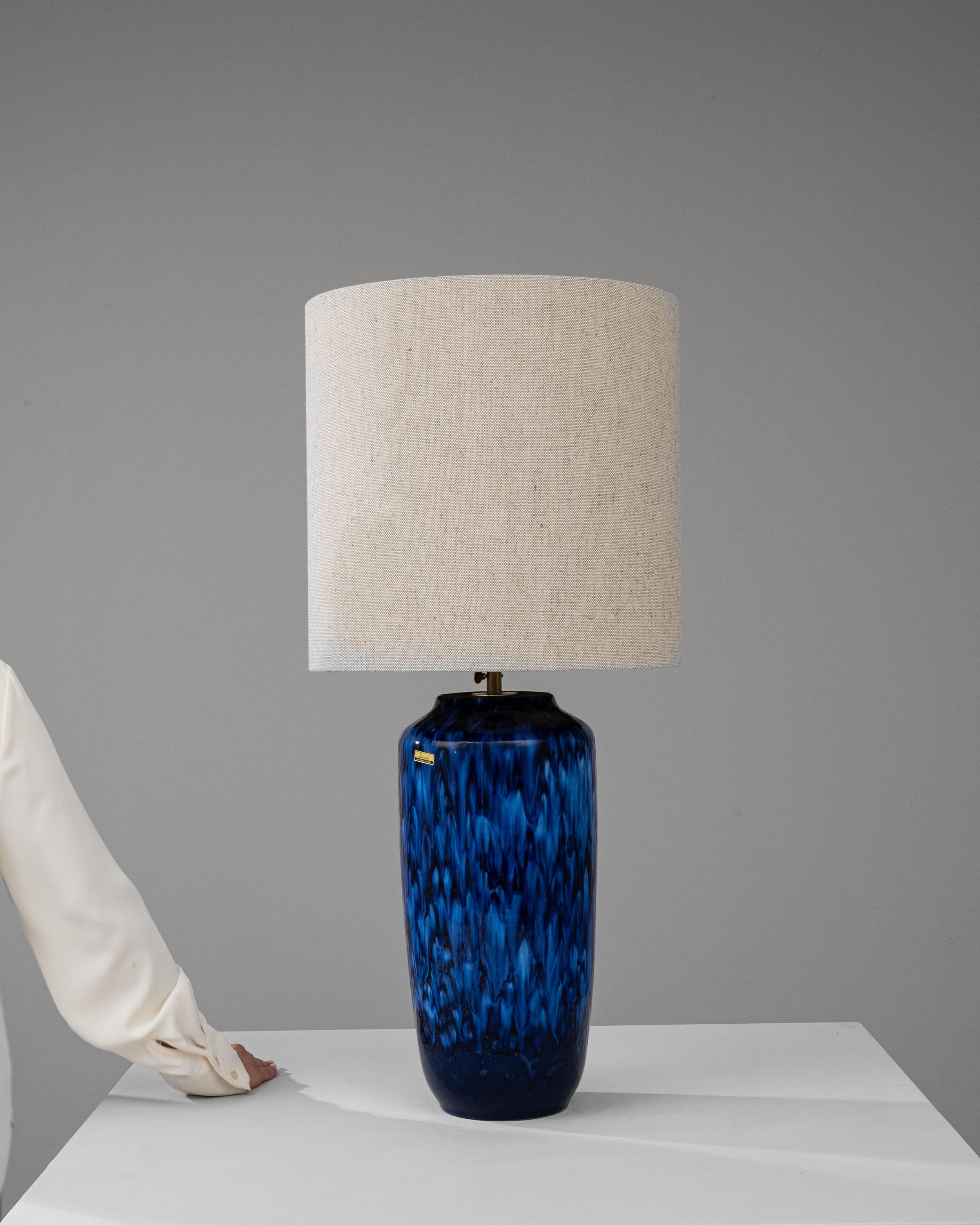 Imbued with the deep blues of the ocean and the sky, this 20th Century German Ceramic Table Lamp from Scheurich's Europ Linie collection is a testament to the company's dedication to quality and style. The lamp's body, with its fluid, cascading