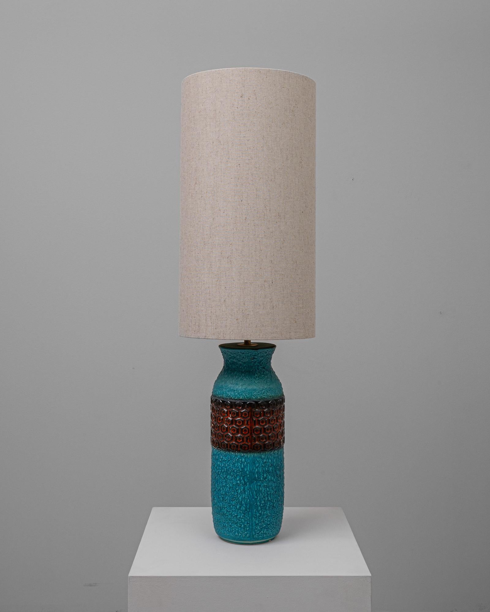 This 20th Century German Ceramic Table Lamp is a symphony of texture and color, reflecting the bold aesthetic movements of its time. The base showcases an intricate crackle glaze in a mesmerizing turquoise that evokes the tranquil beauty of a