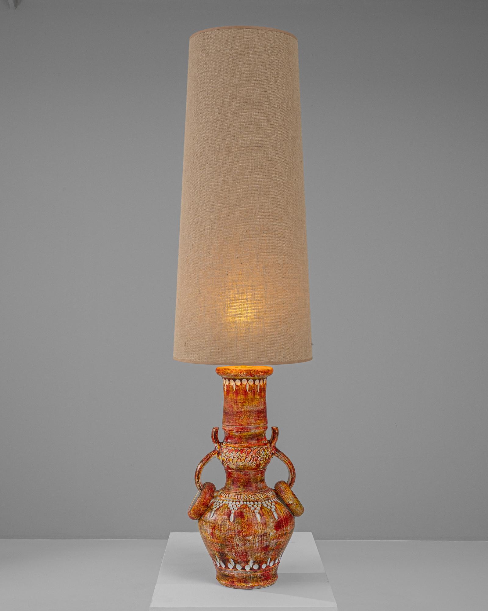 Brighten your home with a touch of artisanal charm using this 20th-century German ceramic table lamp. Expertly crafted, the lamp features a vibrant, multi-hued base adorned with intricate detailing and traditional motifs that evoke a sense of