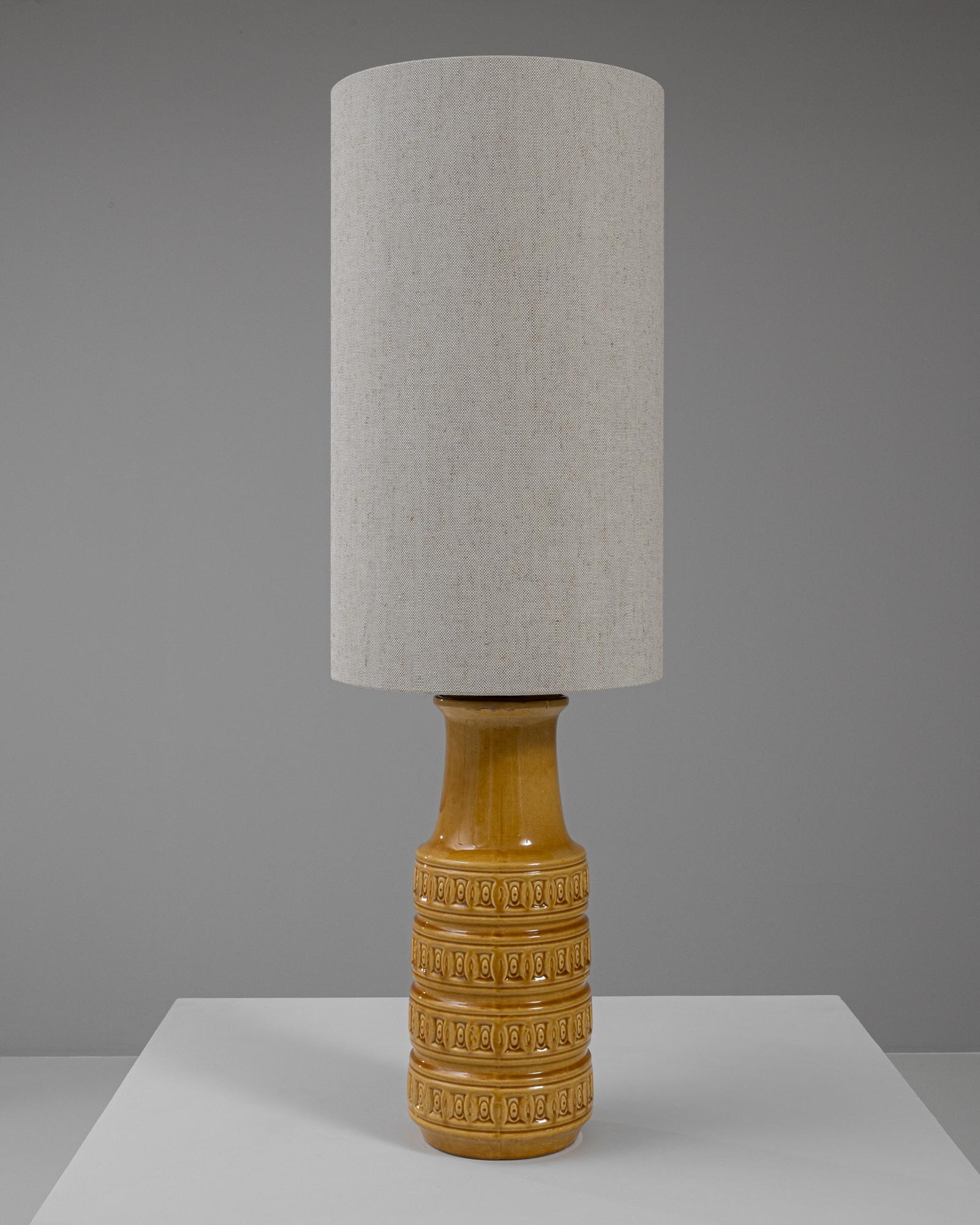 Illuminez votre espace de vie avec cette lampe de table en céramique allemande du XXe siècle, qui arbore une couleur jaune audacieuse et ensoleillée. Cette pièce présente une base en forme de cruche magnifiquement travaillée, ornée de motifs en