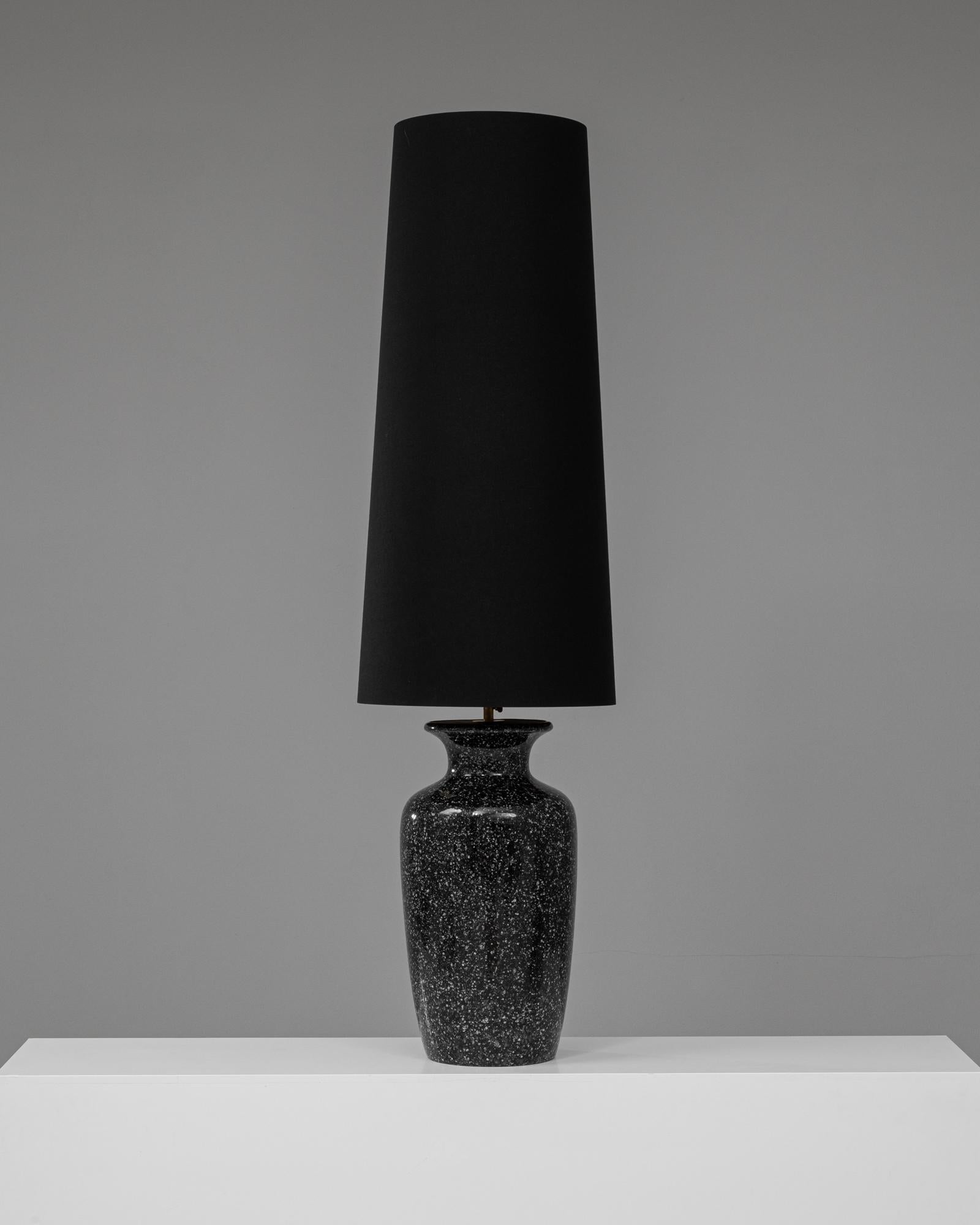 Cette lampe de table en céramique allemande du 20e siècle se distingue par sa base noire mouchetée et élégante qui respire la sophistication et le style contemporain. La finition brillante de la base, avec sa texture subtile, crée un sentiment de
