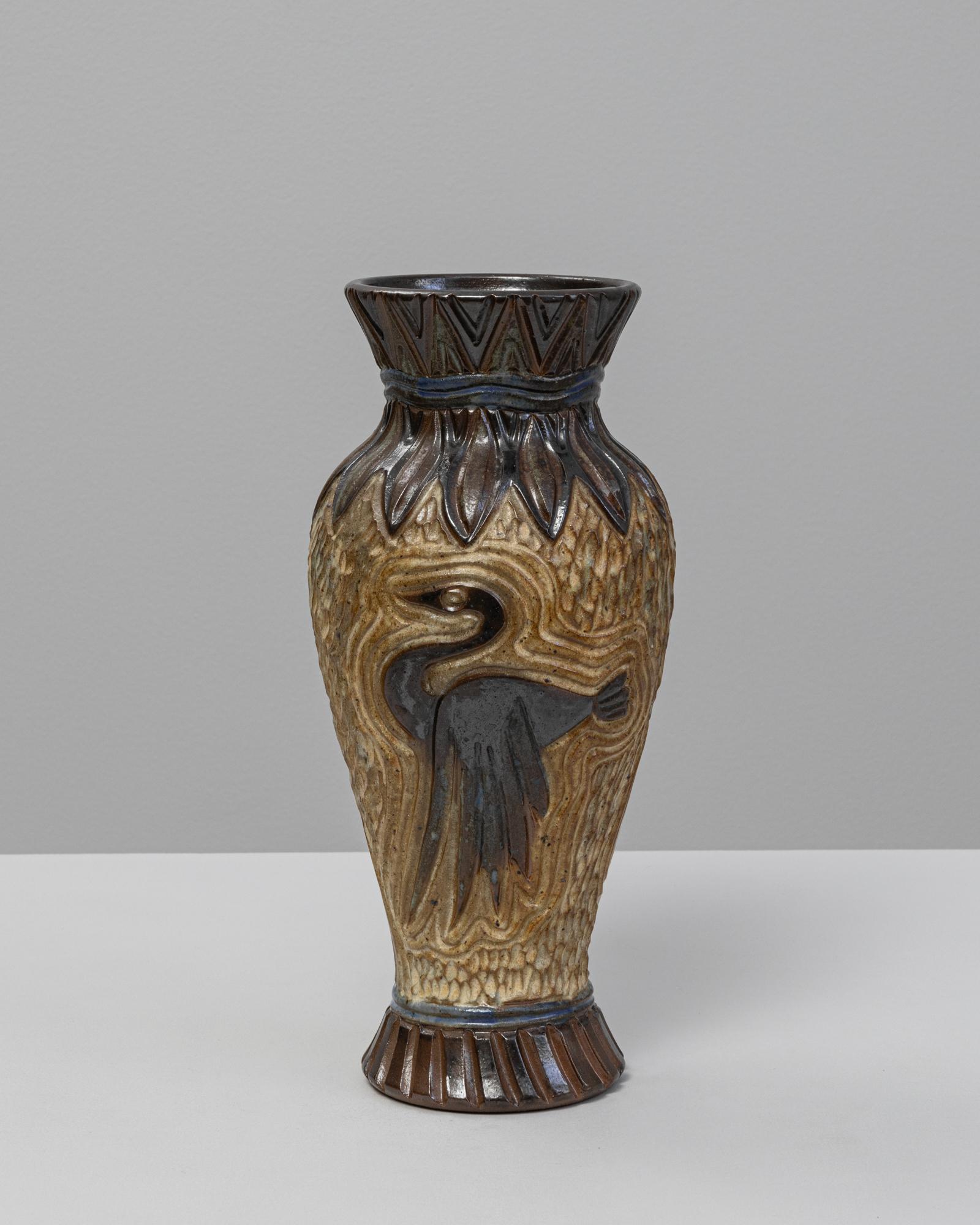 Vaso in ceramica tedesca del XX secolo. Questo vaso dalla lavorazione complessa presenta un disegno in rilievo che raffigura un uccello stilizzato in volo, incorniciato da motivi organici e ritmici che ricordano l'Art Déco e le prime influenze