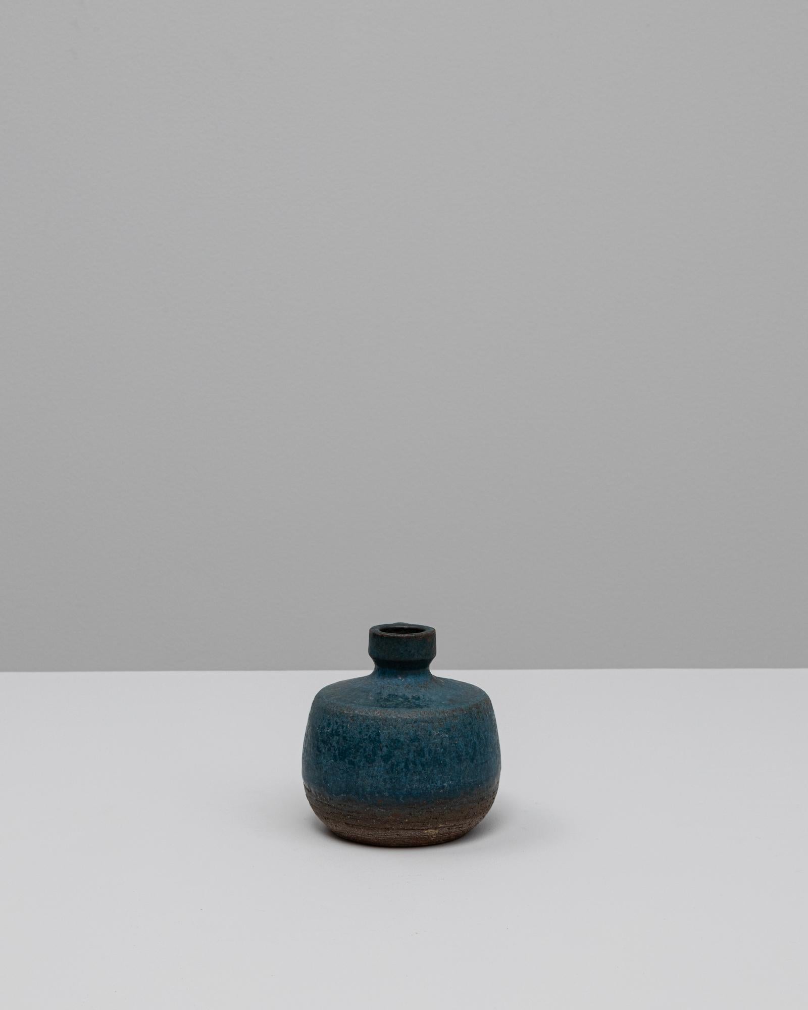 Vase en céramique allemand du 20e siècle. Ce vase compact du milieu du siècle incarne la beauté discrète de la poterie de studio allemande, avec une forme doucement arrondie, un col étroit et une petite anse en boucle. La surface texturée passe d'un