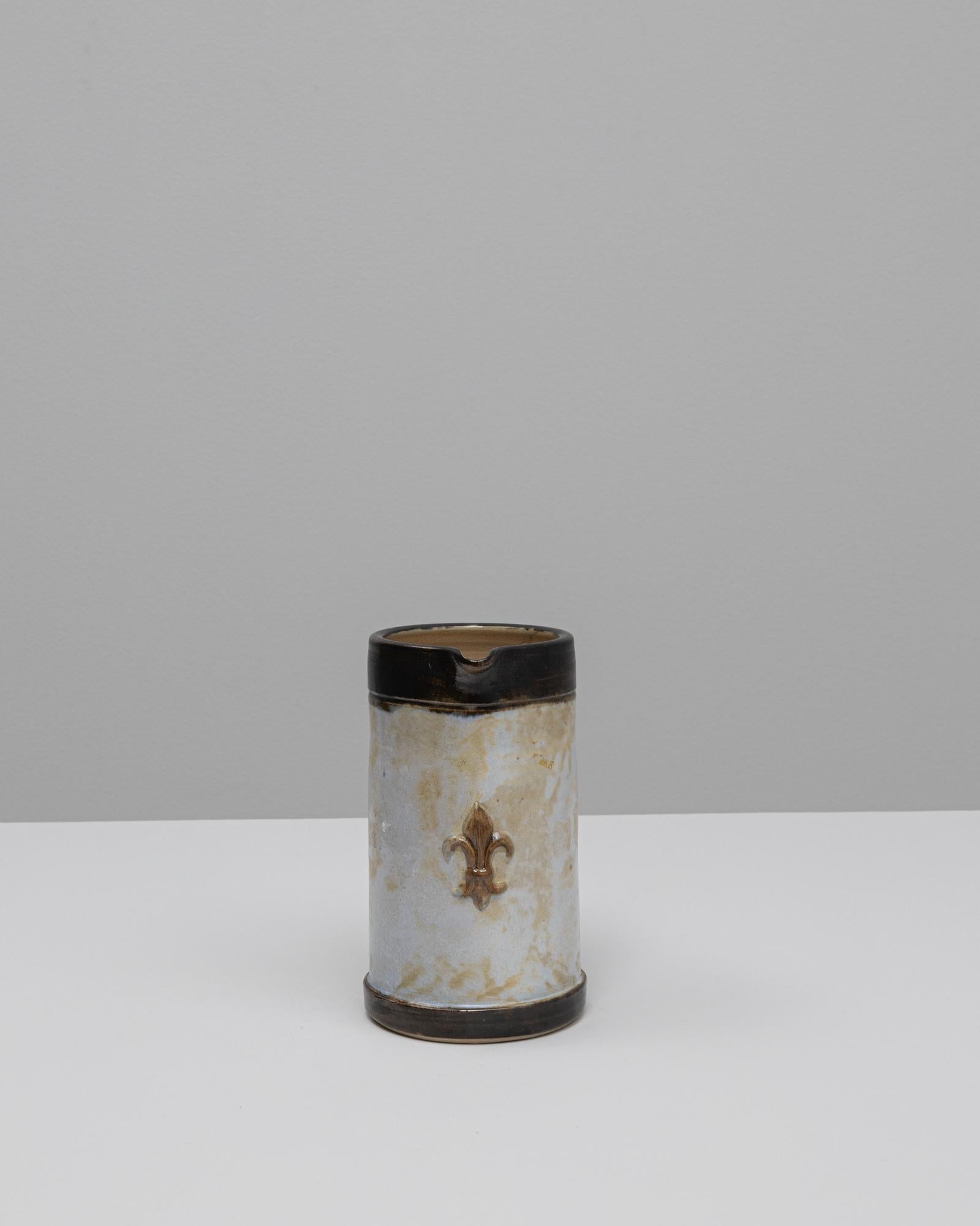 Vase en céramique allemand du 20e siècle. Cette pièce en céramique fabriquée à la main présente une forme cylindrique avec un bec et une poignée prononcés, fusionnant un design fonctionnel avec un charme rustique. La surface est recouverte d'une