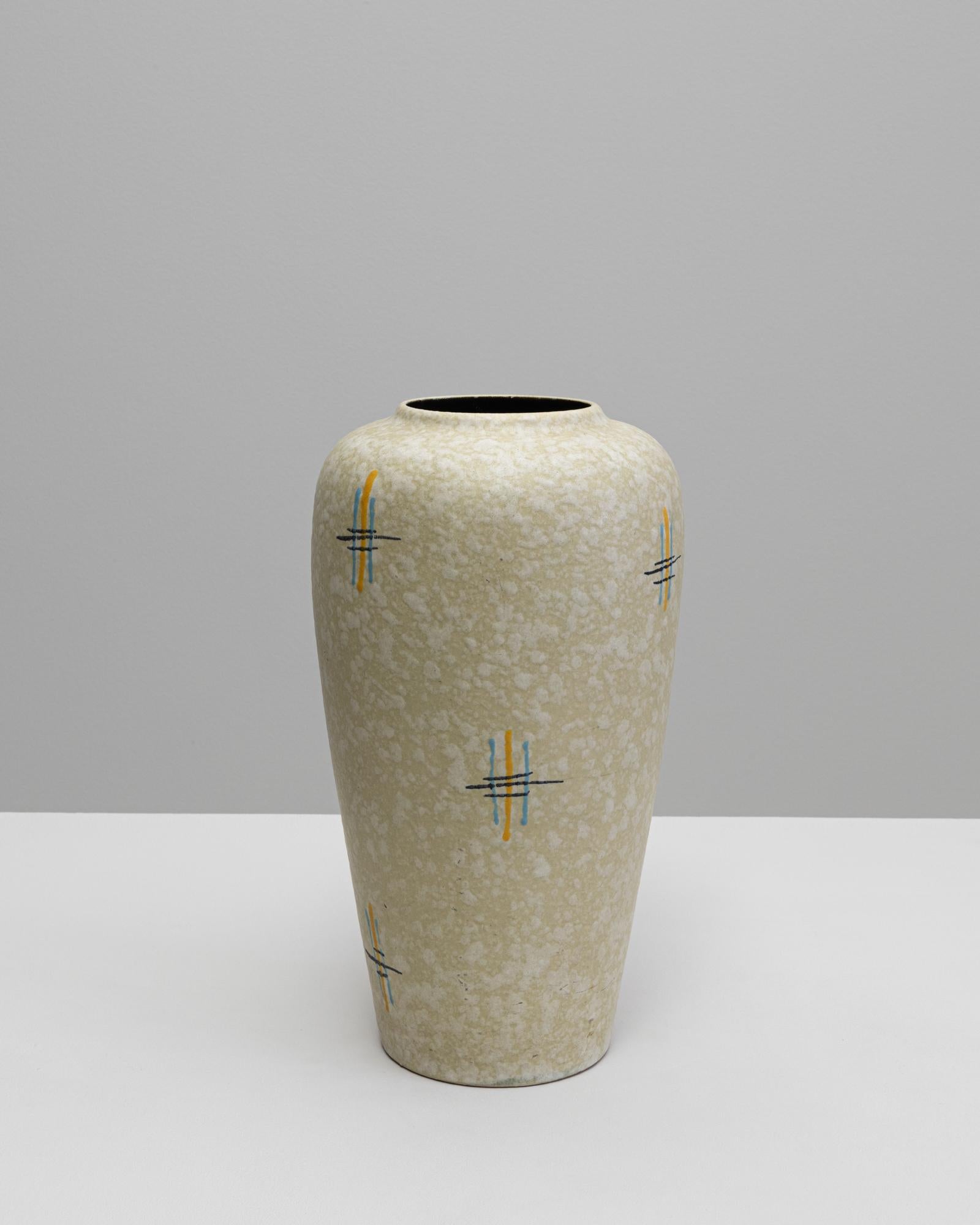 Questo vaso in ceramica tedesca del XX secolo incarna le linee pulite e la sottile maestria caratteristica del design di metà secolo. La sua forma morbidamente affusolata è rifinita con uno smalto crema chiaro con una delicata texture marmorizzata,