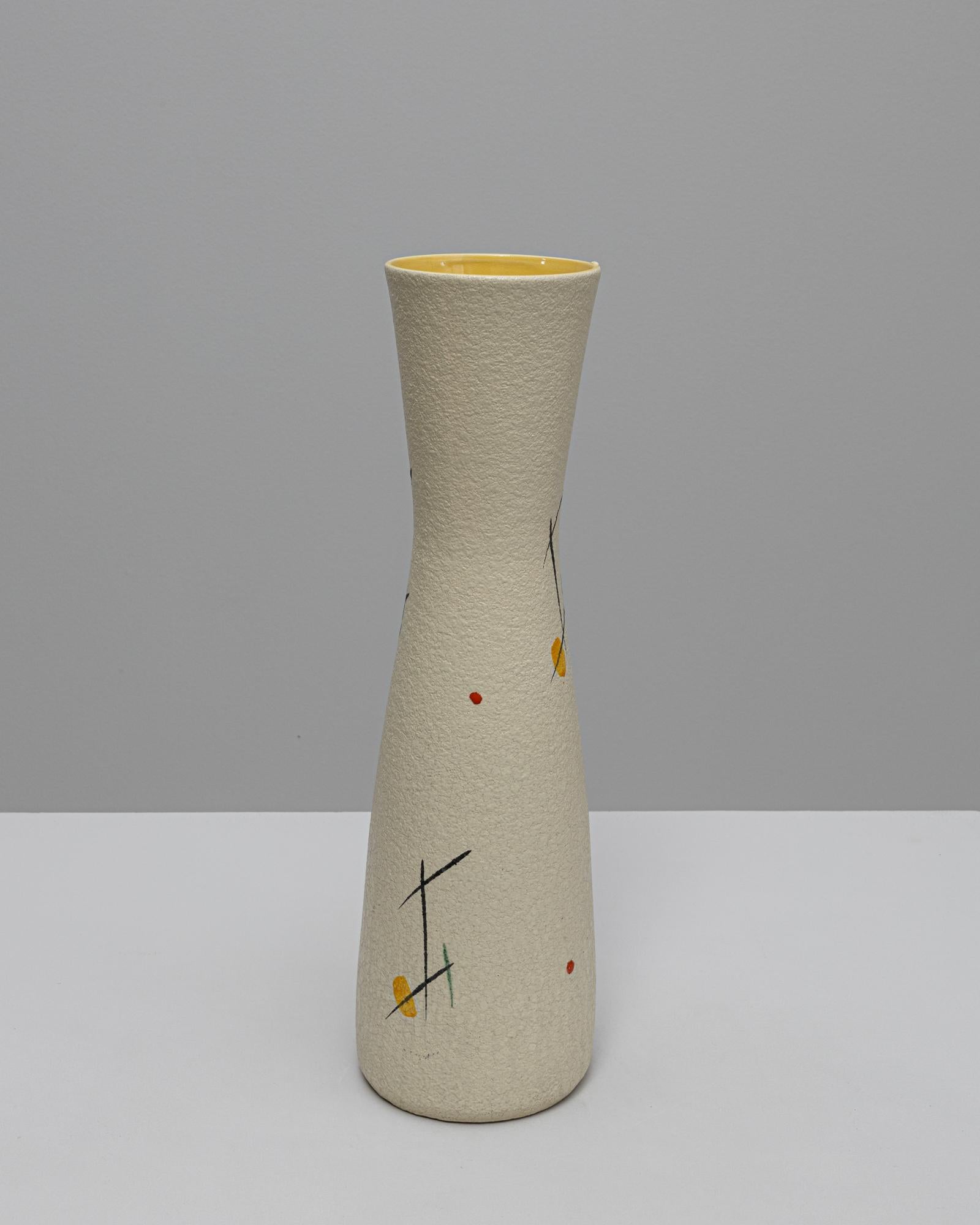 Questo vaso in ceramica tedesca del XX secolo cattura lo spirito del design moderno di metà secolo con la sua silhouette elegante e la decorazione minimalista. La forma alta e svasata è rifinita con uno smalto crema opaco e presenta linee astratte