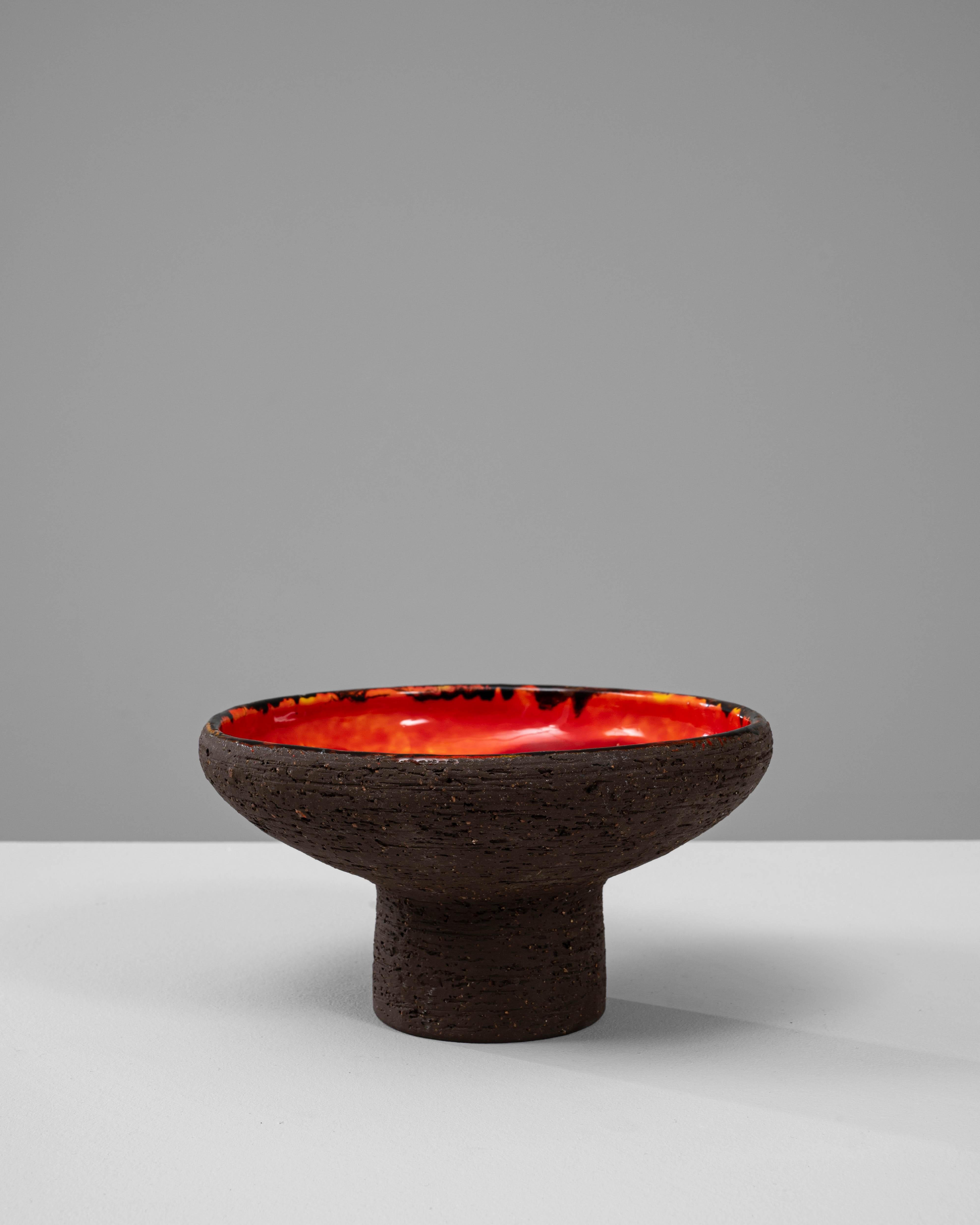 Vaso in ceramica tedesca del XX secolo. Questo sorprendente vaso in ceramica incarna l'estetica audace e strutturata associata al design tedesco della metà del XX secolo, con una silhouette scultorea elevata su una base cilindrica a piedistallo.