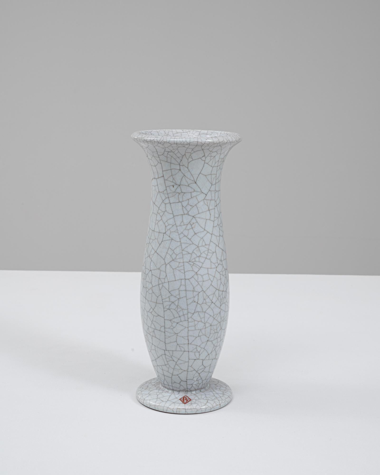Ce vase en céramique allemand du 20e siècle se distingue par sa silhouette raffinée et sculpturale et par son étonnante surface émaillée de craquelures. La forme haute et légèrement effilée s'élève à partir d'un pied arrondi et s'ouvre sur un bord