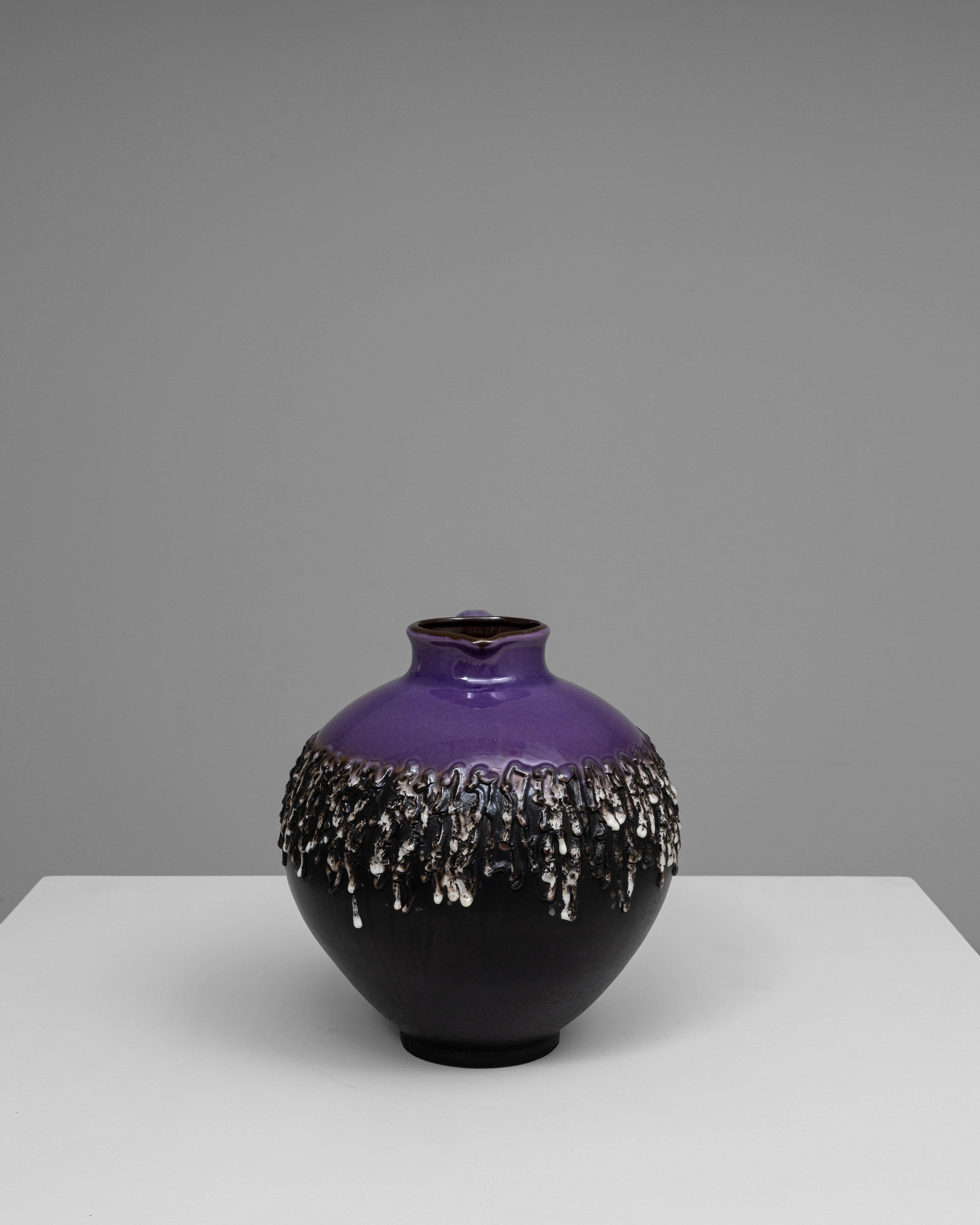 Cette cruche en céramique Fat Lava du 20e siècle incarne l'esthétique audacieuse et expressive qui définissait la poterie ouest-allemande au milieu du siècle dernier. Sa forme arrondie et sa poignée sculpturale constituent une base classique pour le