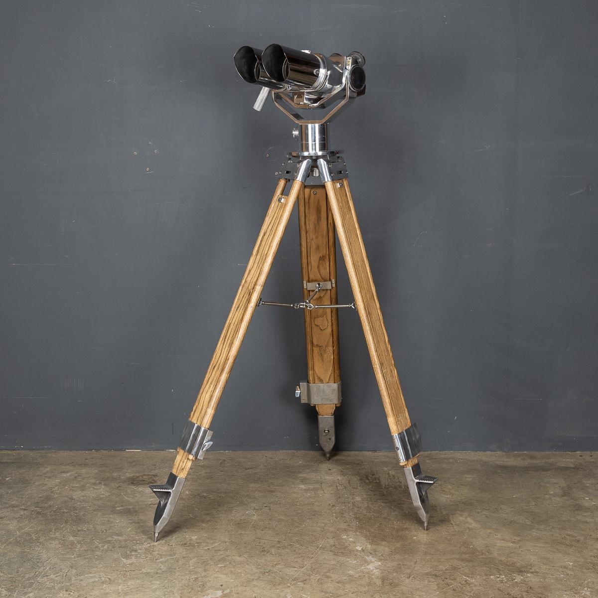 Exceptional 20th century German polished steel observation binoculars on a later telescopic stand by D.F. This model was originally designed by Emil Busch and it has been adopted by the military in 1936. The model is suitable for both day and night