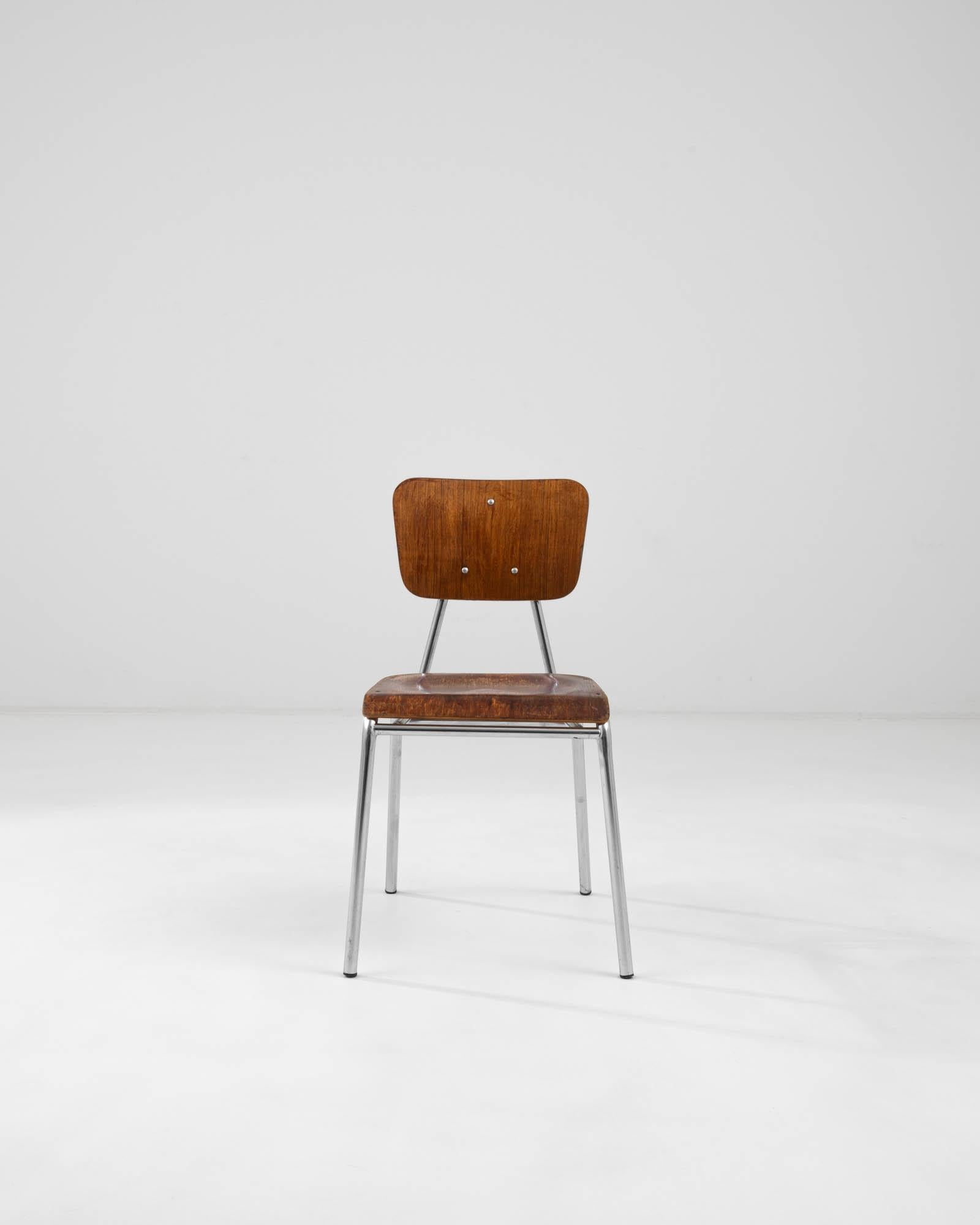 Chaise de salle à manger en bois créée en Allemagne au milieu du XXe siècle. Ornée et bien structurée, cette chaise de salle à manger élégante projette une image de calme et d'alerte, rappelant un type plus familier de siège de salle de classe,