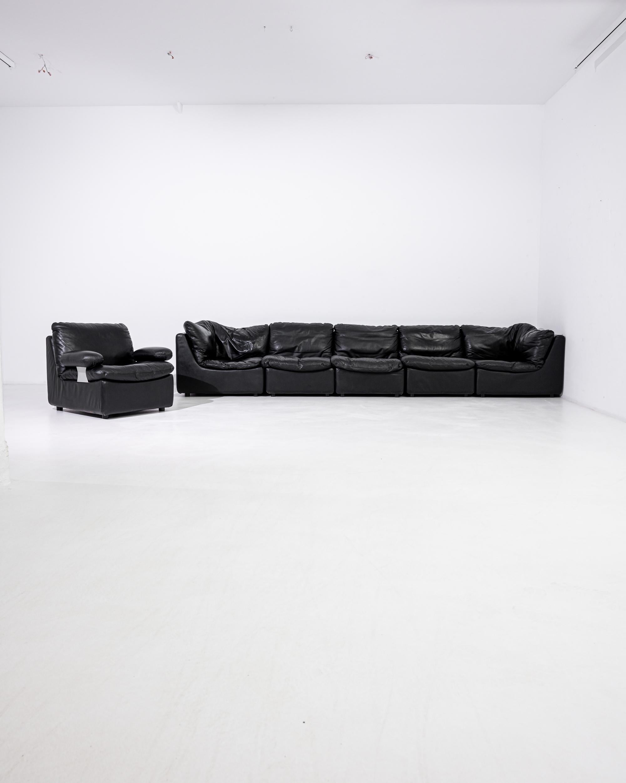 Seductively comfortable, this vintage modular sofa made in Germany features five units with one individual armchair. Upholstered in classy black leather, the modules have soft puffy cushions and a leather-clad frame that gently curves on the