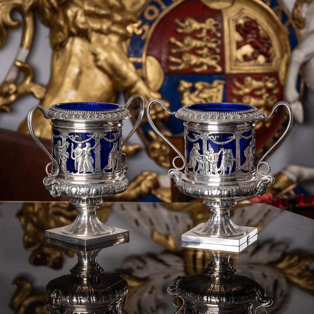 Antique early 20th century German pair of solid silver & royal blue glass wine coolers. Of campana form, the sides applied with frieze of classical biblical scenes, beside Grecian columns and laurel garlands, to each side applied with twisted snake