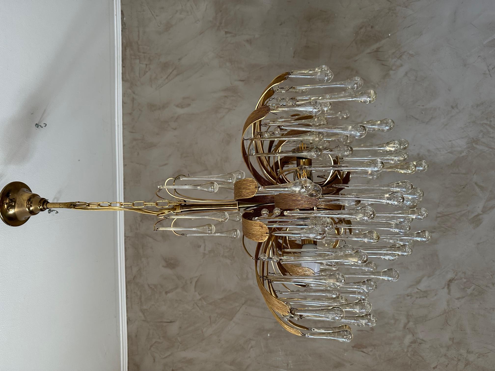 Magnificent gilded brass chandelier from Palwa (Germany) from the 70s.
This stunning chandelier features a gold brass Sputnik, gold textured leaves forming a large flower and elongated Murano glass drops beautifully arranged on several levels, like