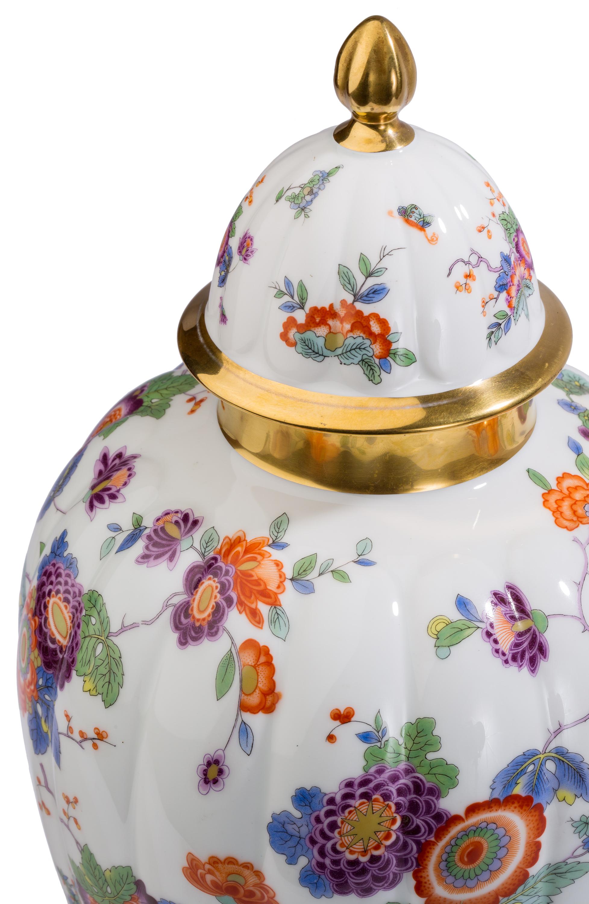 Colorfully decorated with Asian style flowers and storks and with gilt detailing, this lidded porcelain jar / vase / urn was made by Thomas of Bavaria. According to the style of mark on the bottom of the piece, it was manufactured in 1931.