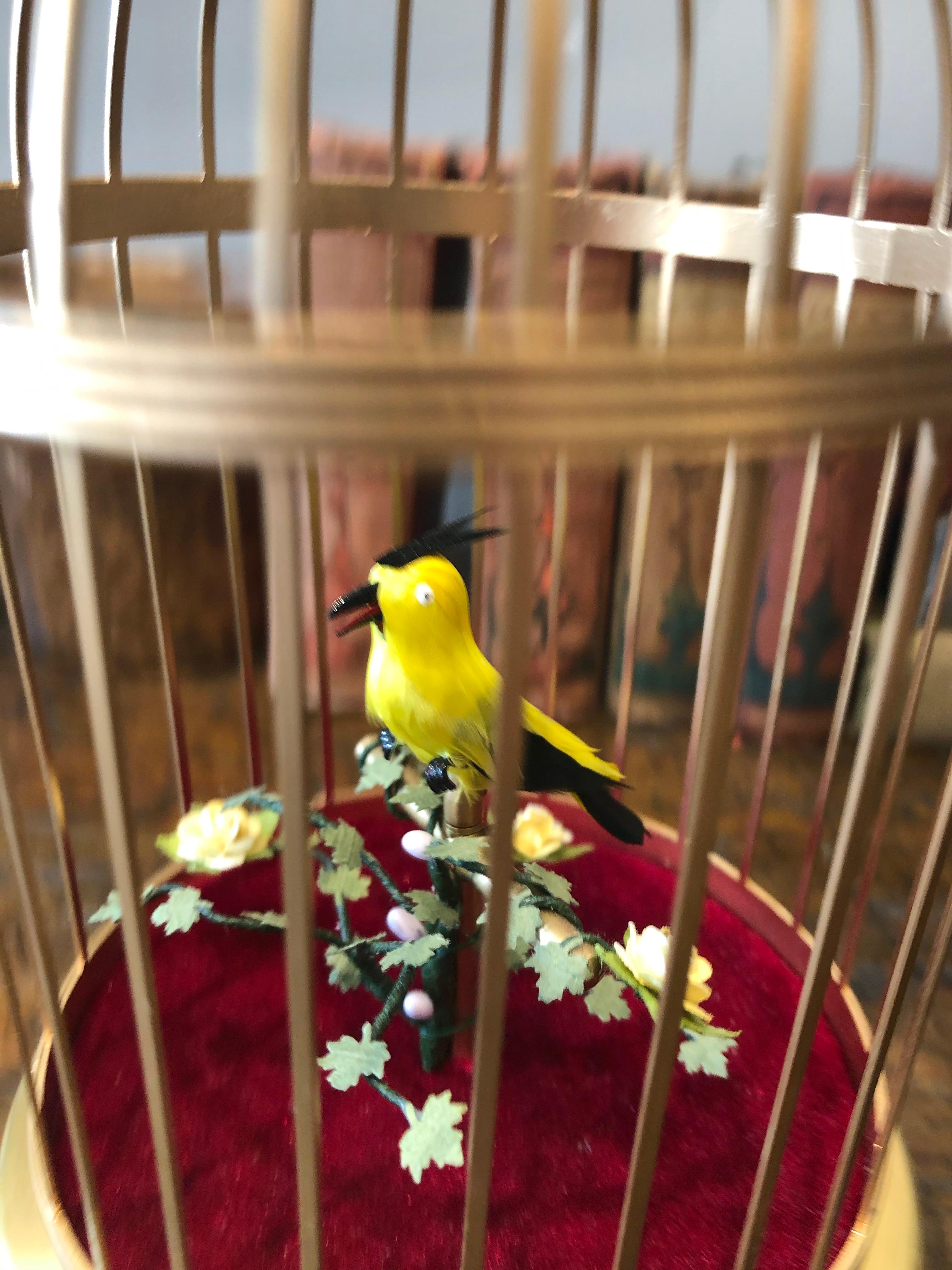 20th century musical bird automaton. An automated singing bird with a strong voice and flamboyant plumage amidst foliage in a gilded brass cage. Made in Germany, circa 1940.
